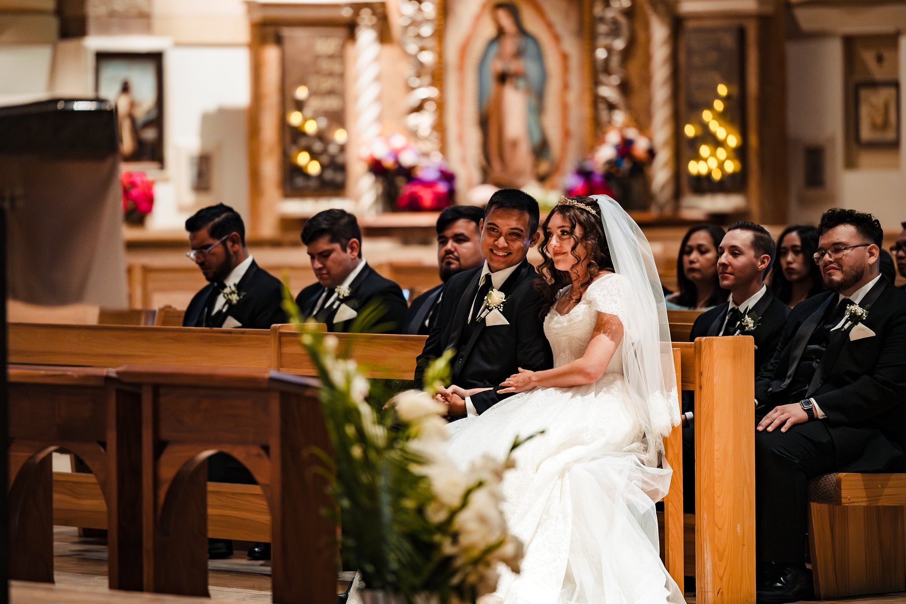 The married couple before the image of Our Lady of Guadalupe after the Catholic wedding in Murrieta