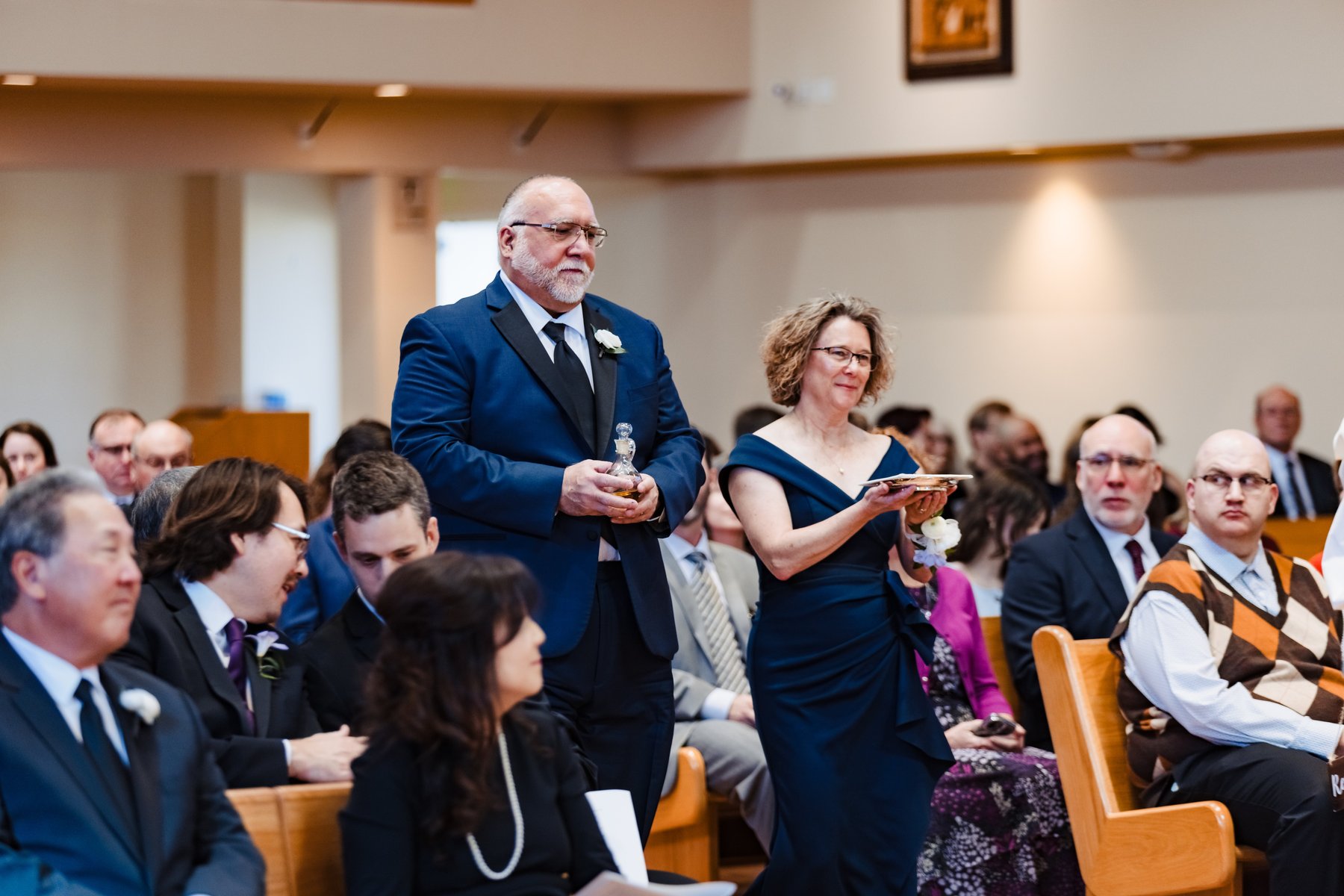 Parents bring up the gifts during the offertory procession at the Nuptial Mass