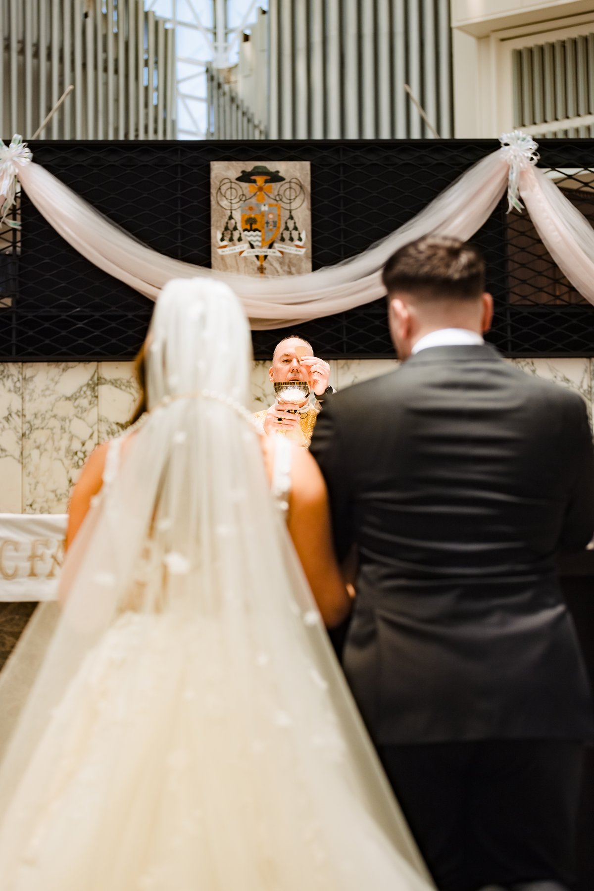 The elevation of the host during the Catholic wedding Mass at Christ Cathedral
