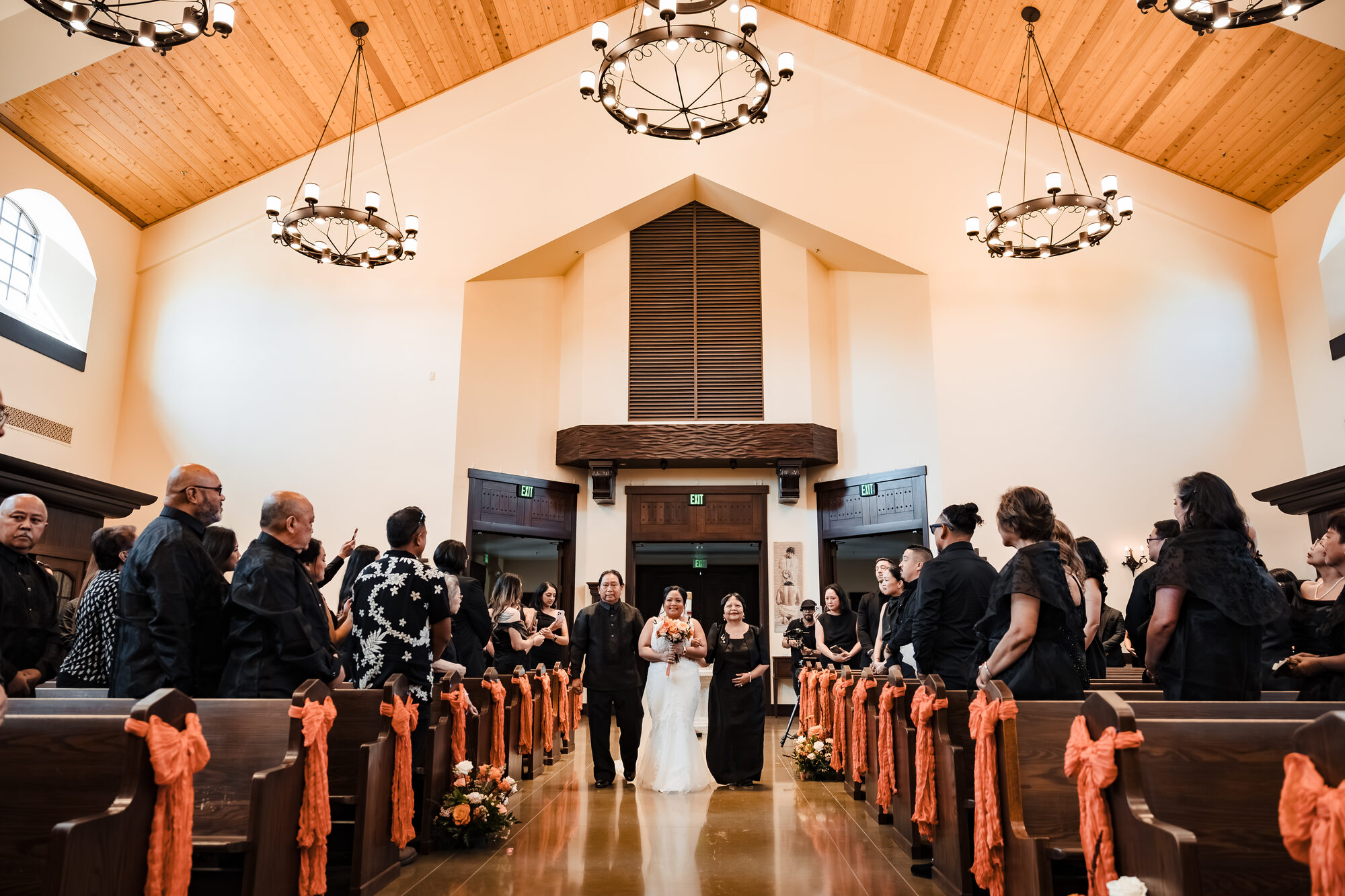Bride processing down the aisle with her parents at a Catholic wedding in Winters, California