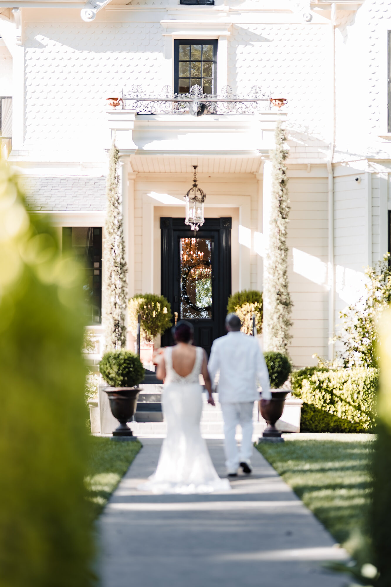 Bride and groom walking toward the Park Winters Victorian house