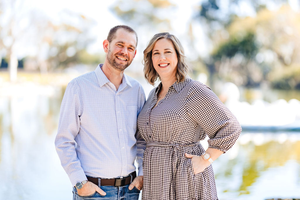 A husband and wife portrait by the water