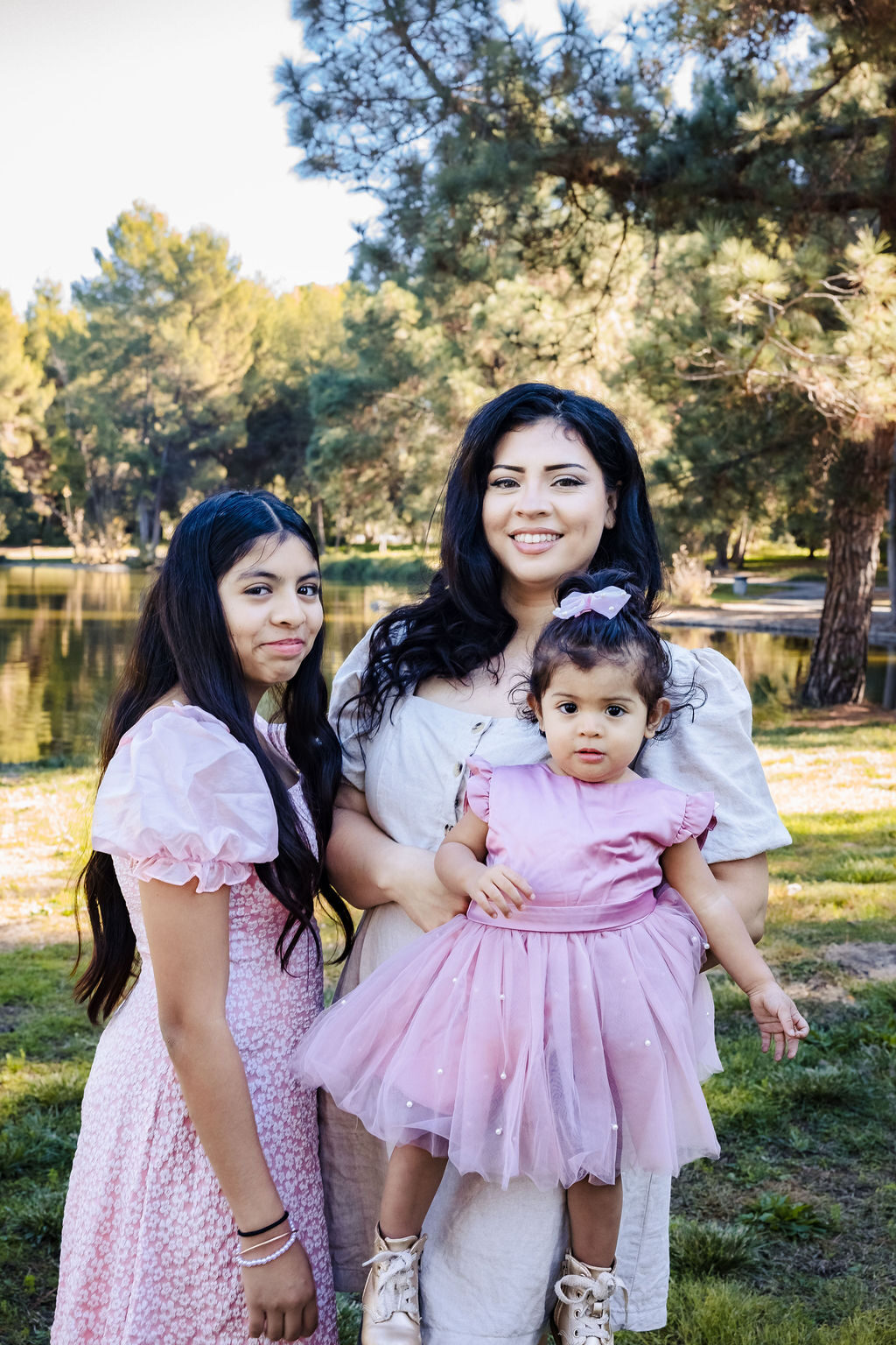 A mother with her two daughters of different ages by a lake