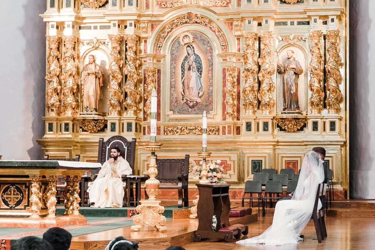 The gilded retablo of Mission Basilica San Juan Capistrano during a Catholic wedding
