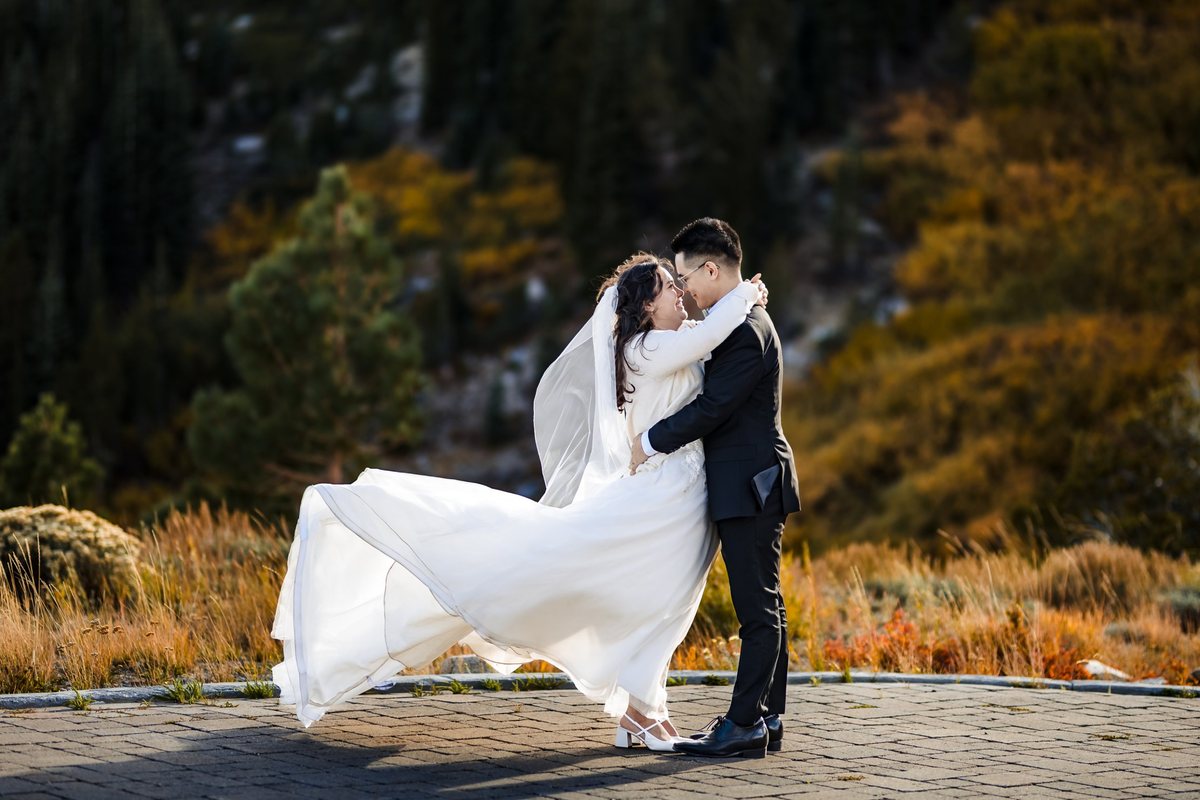Vincent and Ginger kissing in the wind at Winters Creek Lodge after their Catholic wedding at St. Albert the Great, Reno