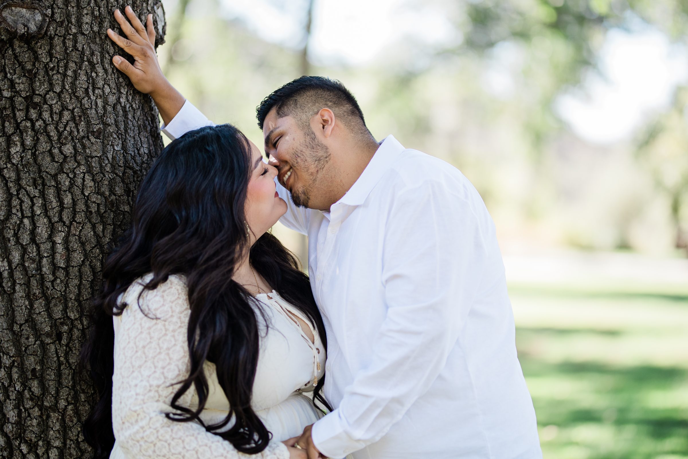 Eric kissing Cristina against the trunk of an old oak at Oak Glen Preserve