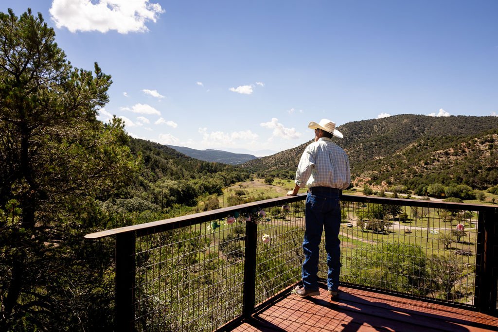 A guest in a cowboy hat taking in the view from the overlook deck