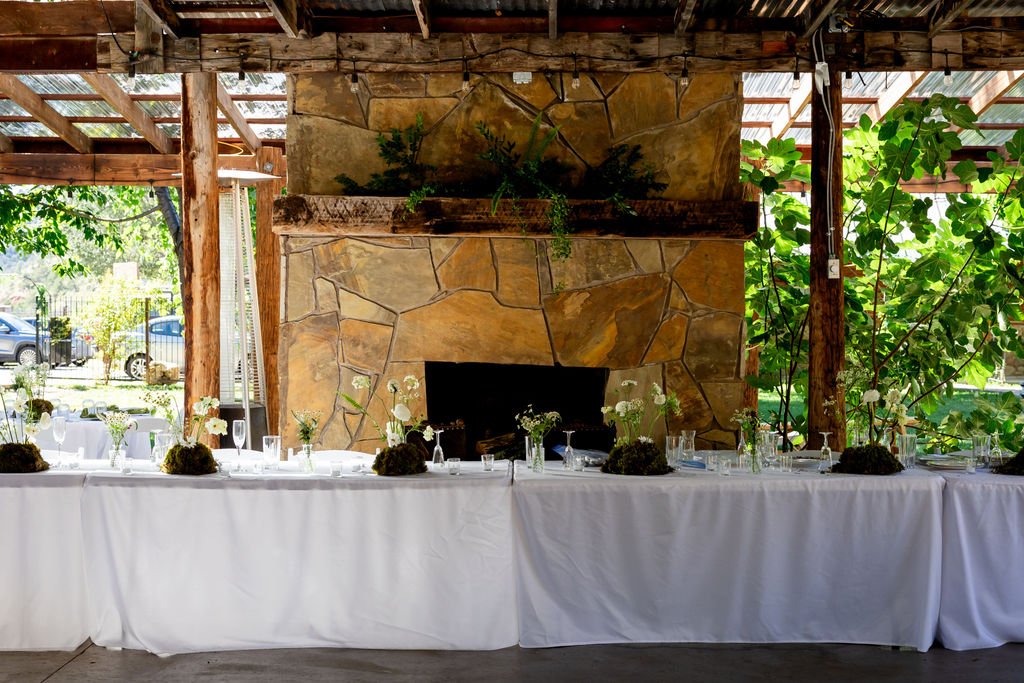 The stone fireplace in the covered pavilion set for the reception