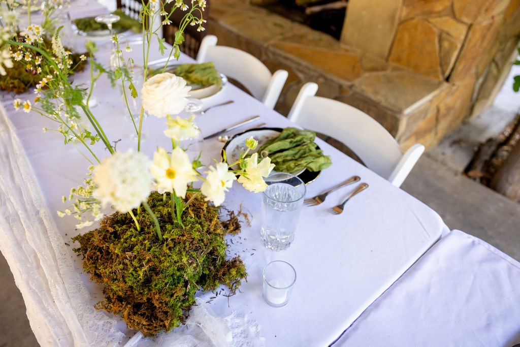 Moss and wildflower centerpieces on the reception tables