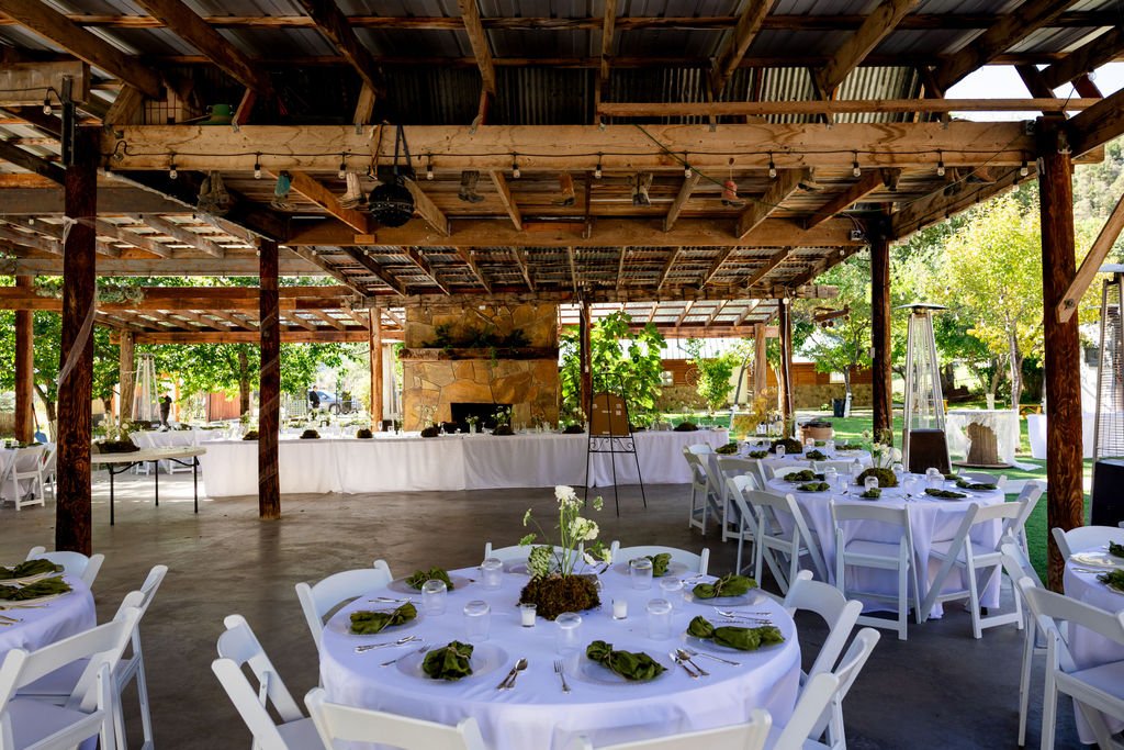 The covered pavilion at Aspen Falls set with round tables for the reception