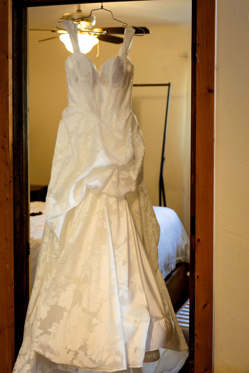 The gown hanging in a cabin doorway beneath the ceiling fan