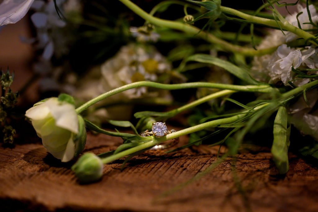 The engagement ring resting among wildflowers on a wooden table