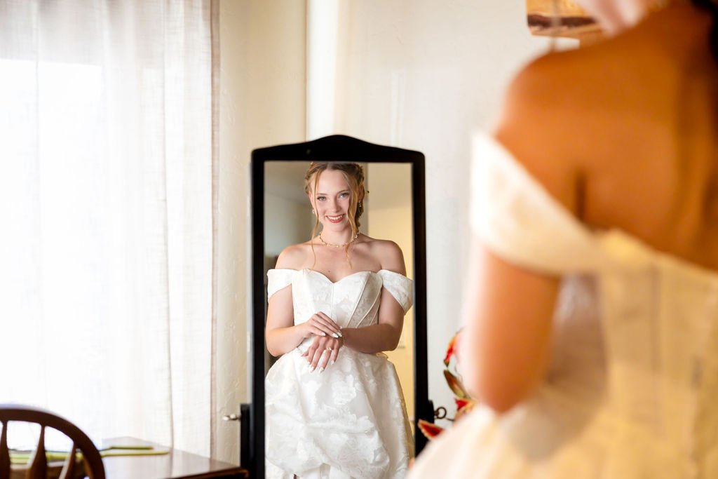 The bride smiling at herself in the mirror