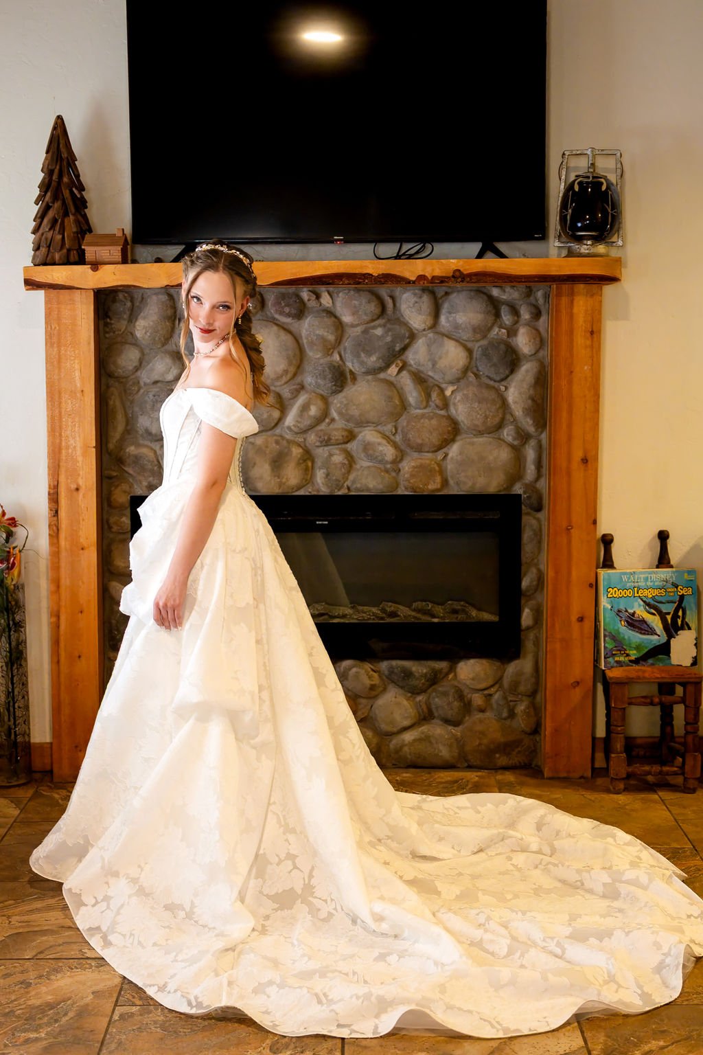 Bridal portrait beside the river-rock fireplace in the cabin