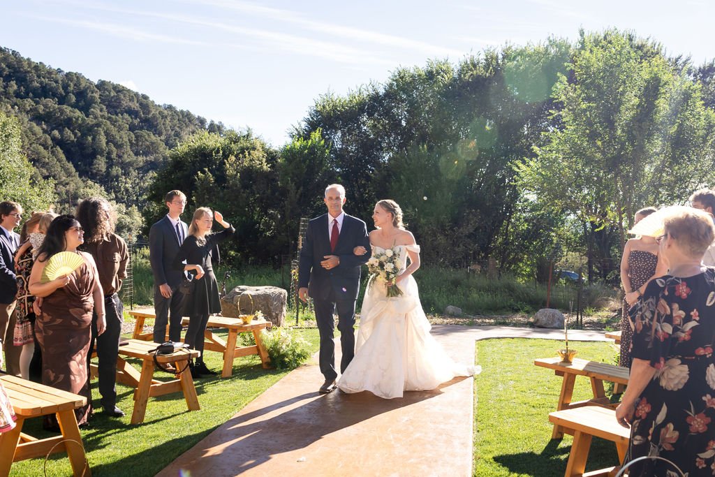 Guests turning to watch the bride and her father come down the aisle