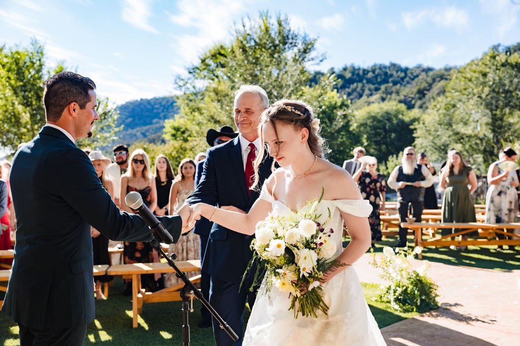 The bride's father giving her hand to the groom