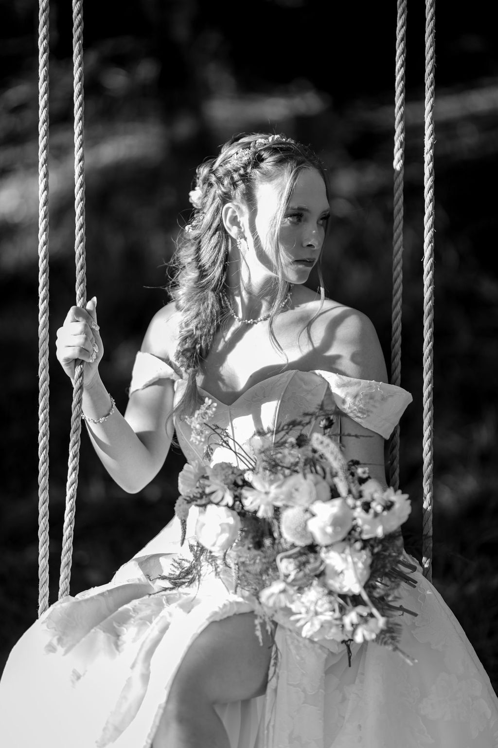Black and white of the bride on the rope swing
