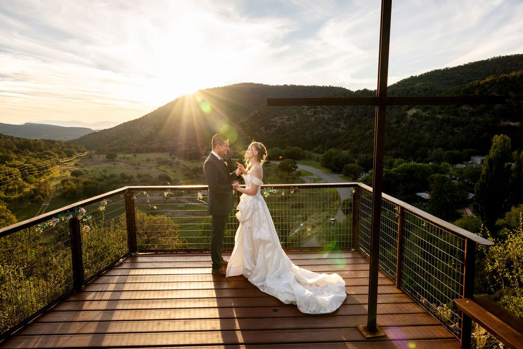Francis and Aubrey on the overlook deck beside the wooden cross at sunset
