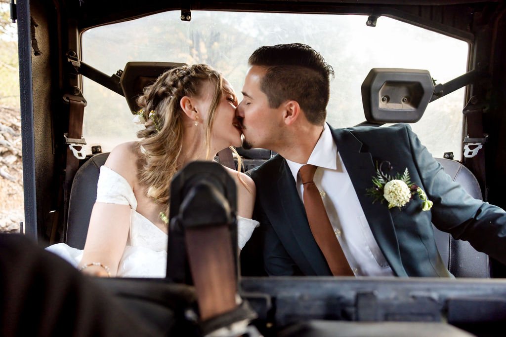 The couple kissing in the back of a side-by-side