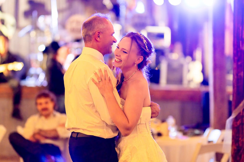 The bride sharing a dance under purple stage lights