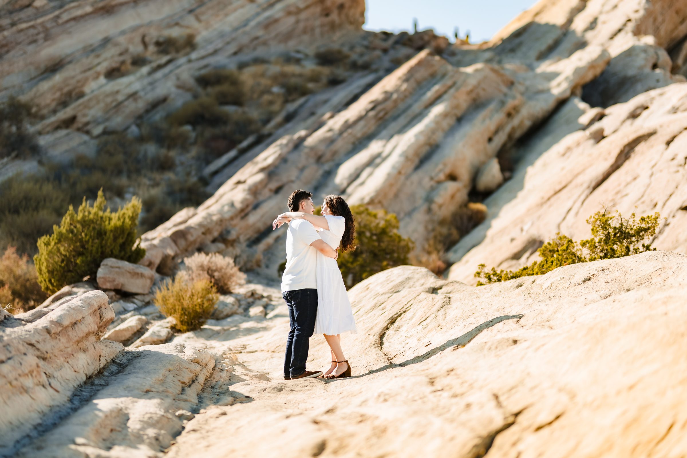 Enrique lifting Daniela for a kiss beneath the tilted sandstone of Vasquez Rocks