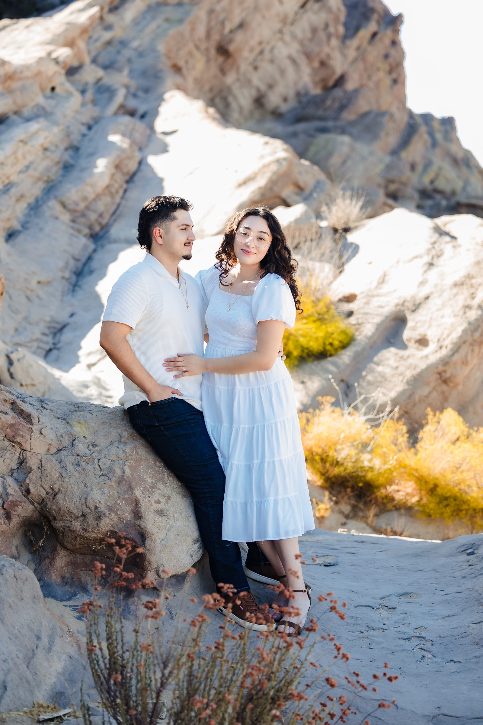 Daniela laughing as Enrique holds her close against the rocks