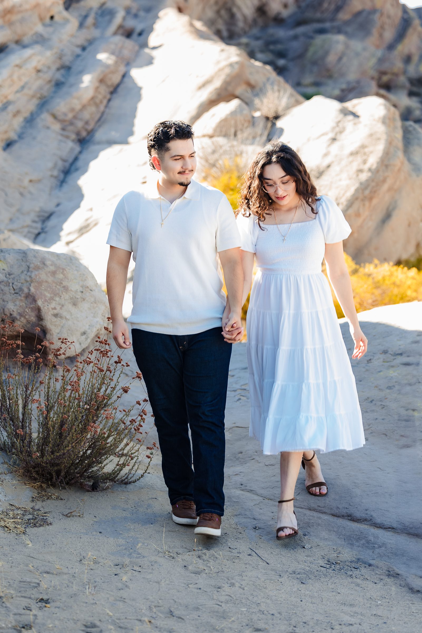 Enrique and Daniela walking hand in hand across the rock at Vasquez Rocks
