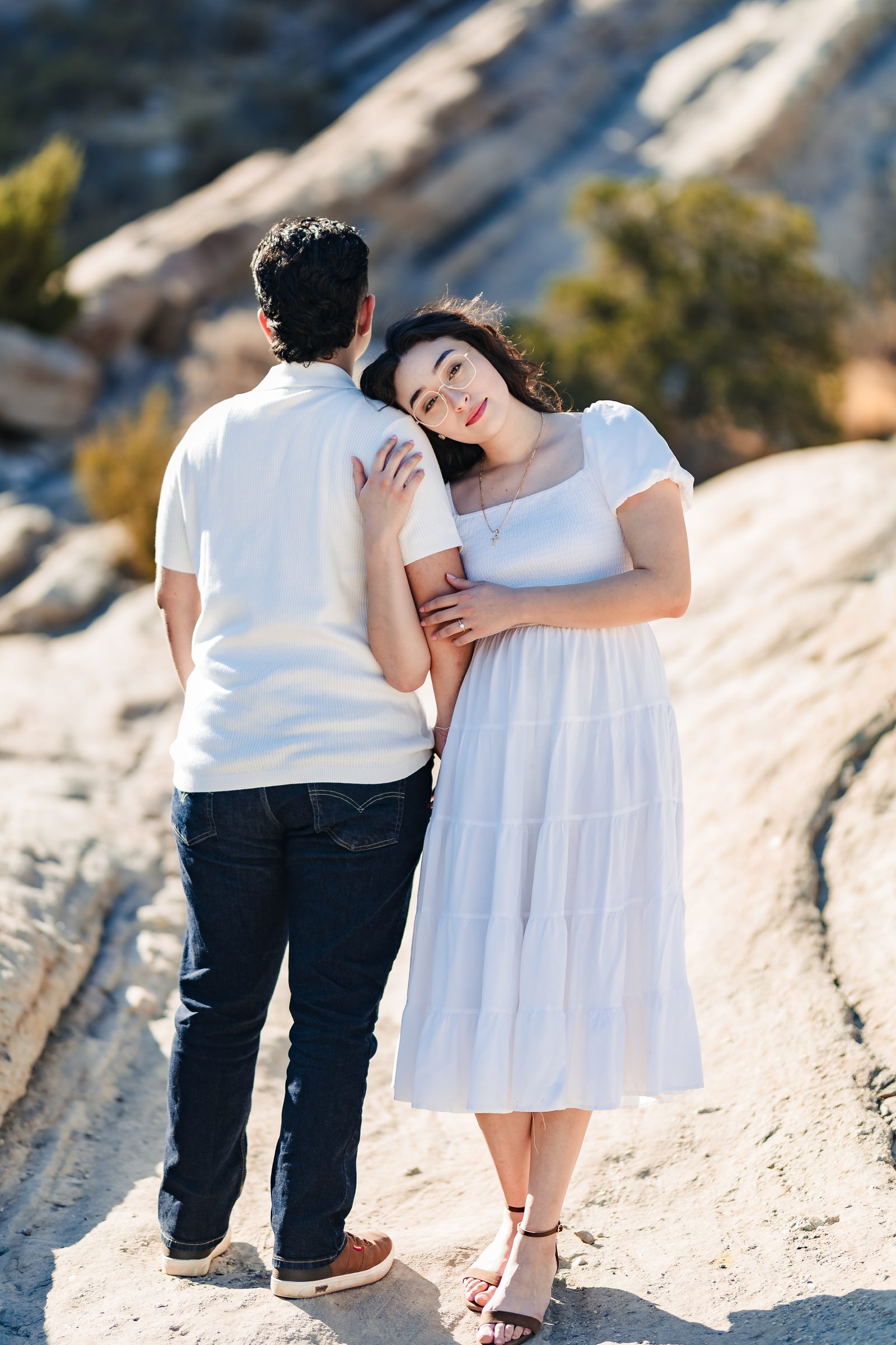 Daniela resting her head on Enrique's shoulder on the slanted sandstone