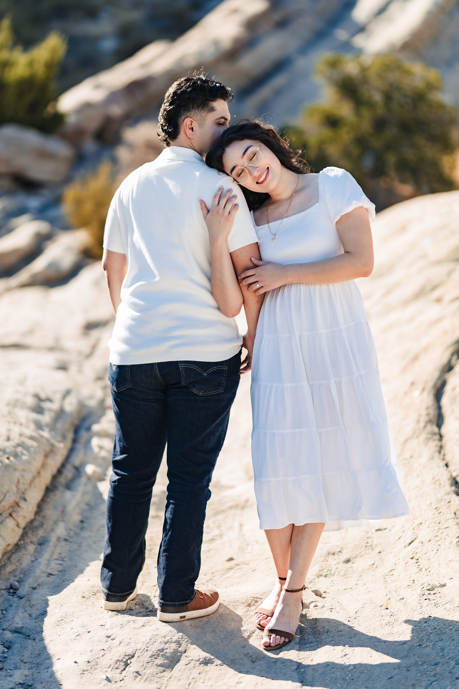 Enrique and Daniela standing close on the tilted rock