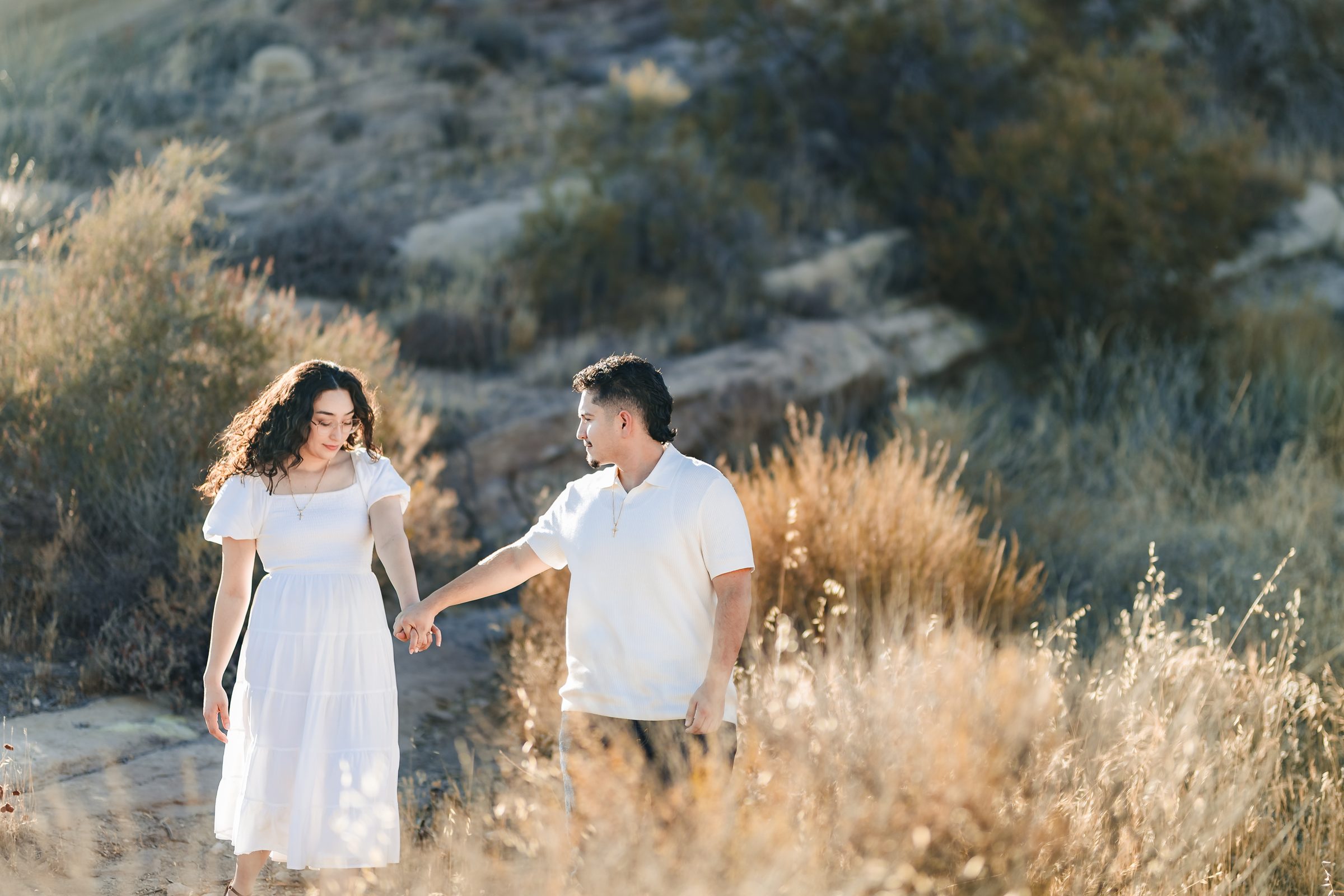 The couple walking through tall golden grass