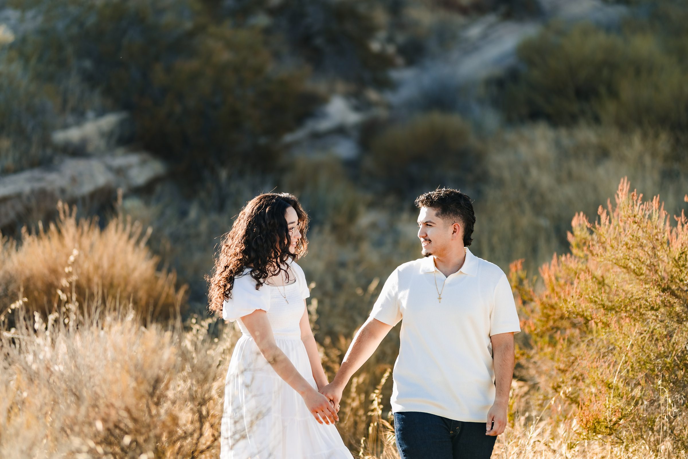 Enrique and Daniela holding hands in the grass