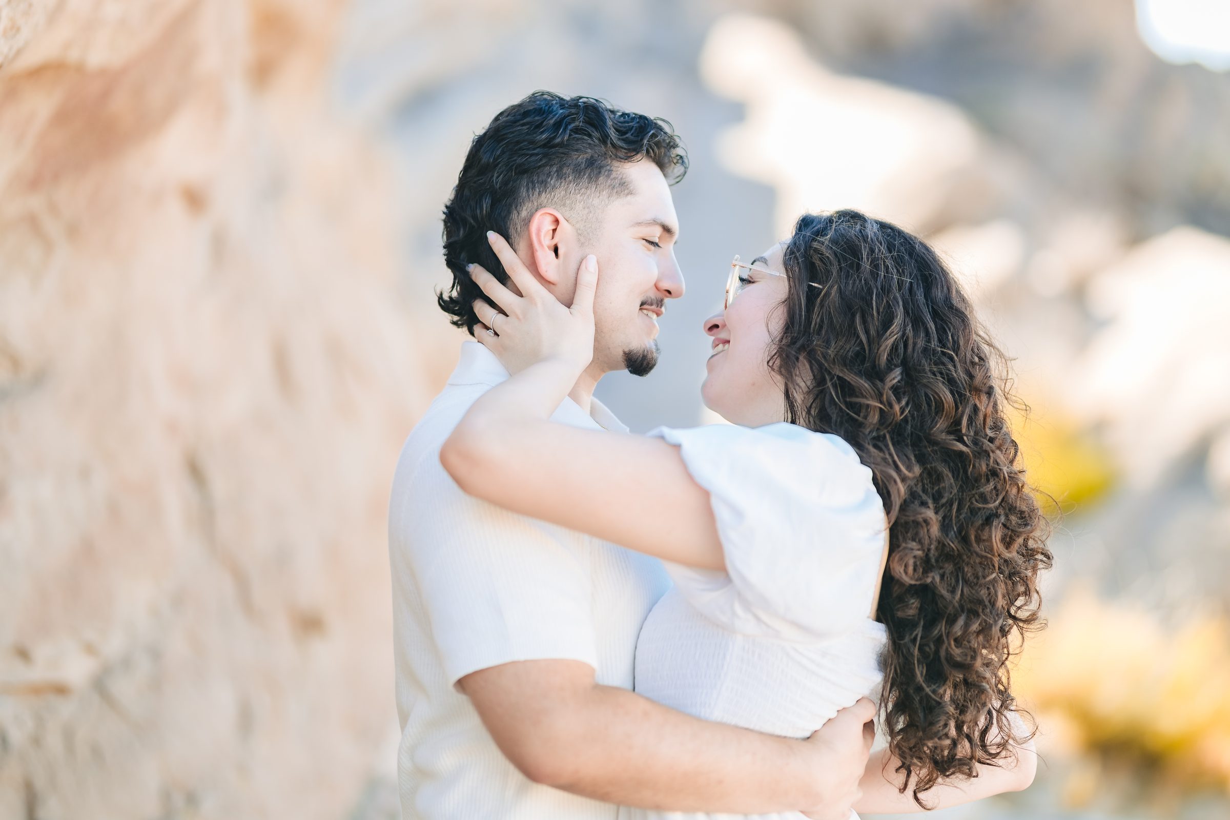 Enrique and Daniela about to kiss with the rocks behind them