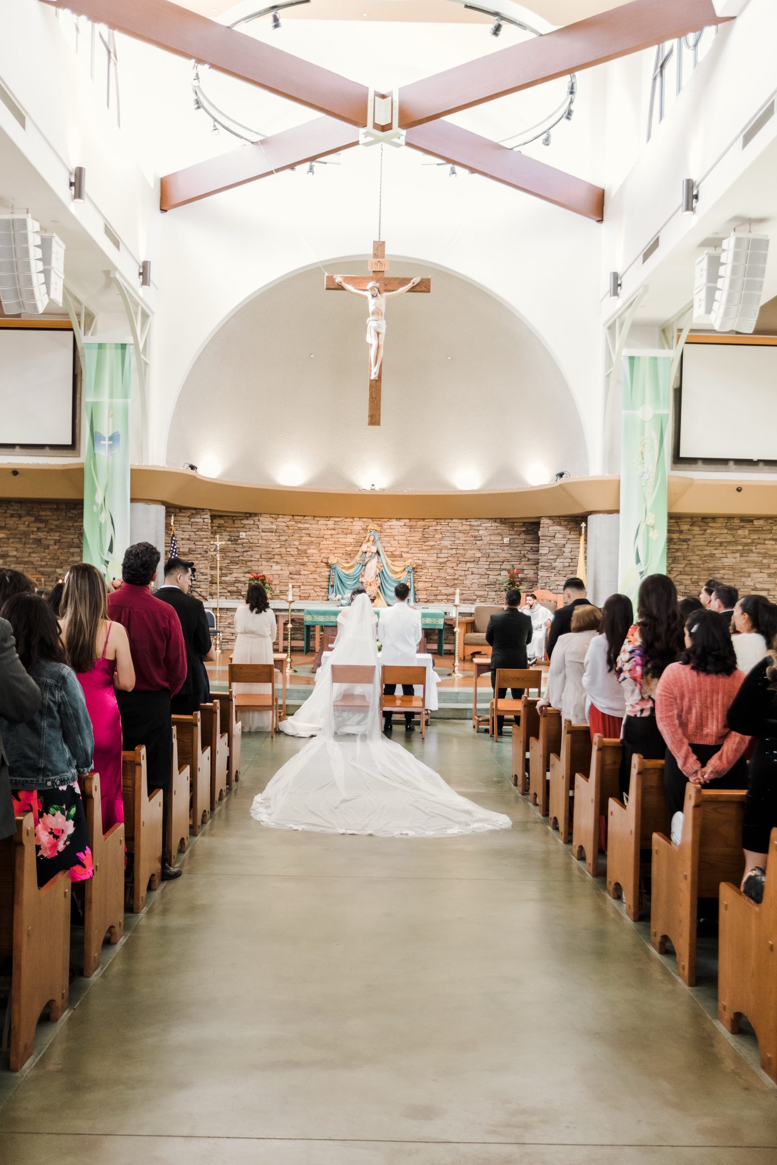 A bride's cathedral veil down the aisle at La Purísima, Orange