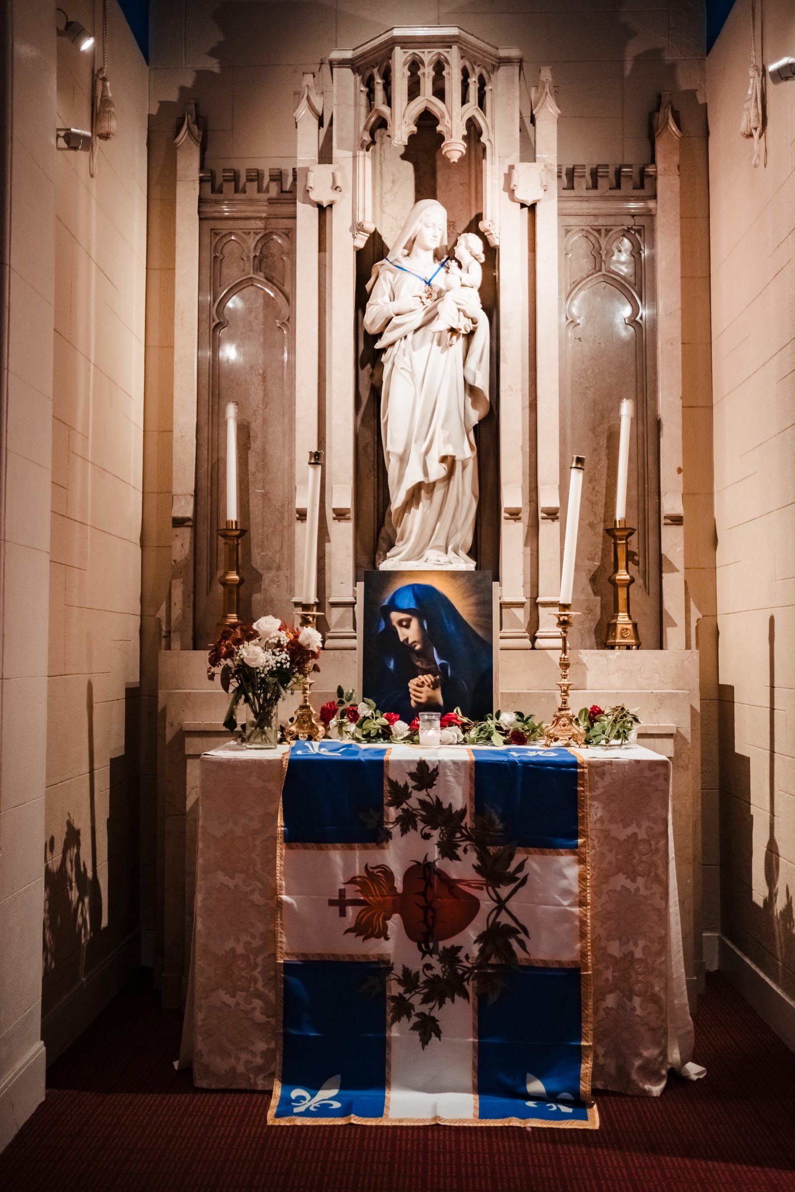 The Marian side altar at Our Lady of Refuge with a Sacred Heart banner and roses