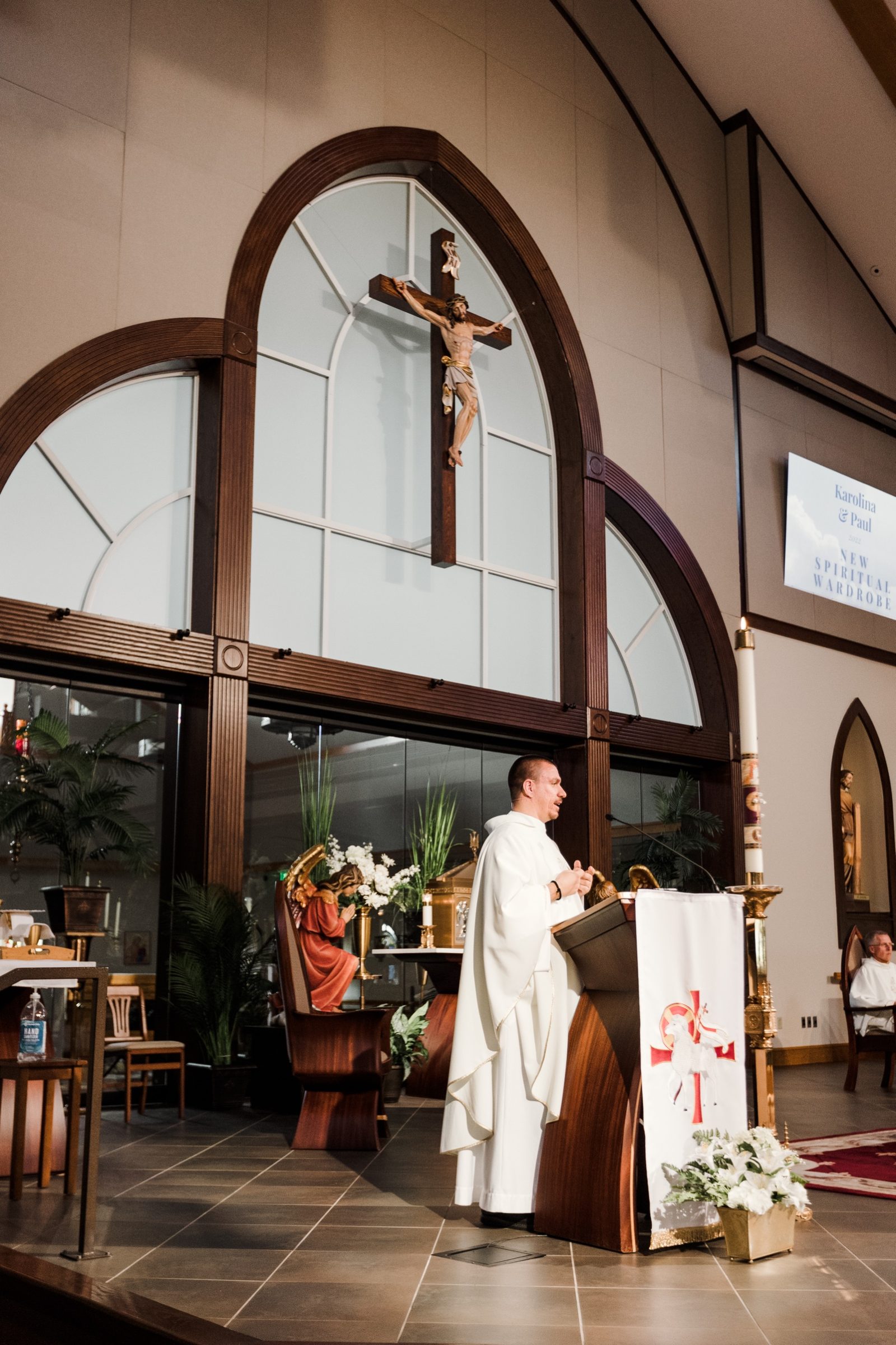 The homily beneath a crucifix framed by arched windows at St. Mark the Evangelist