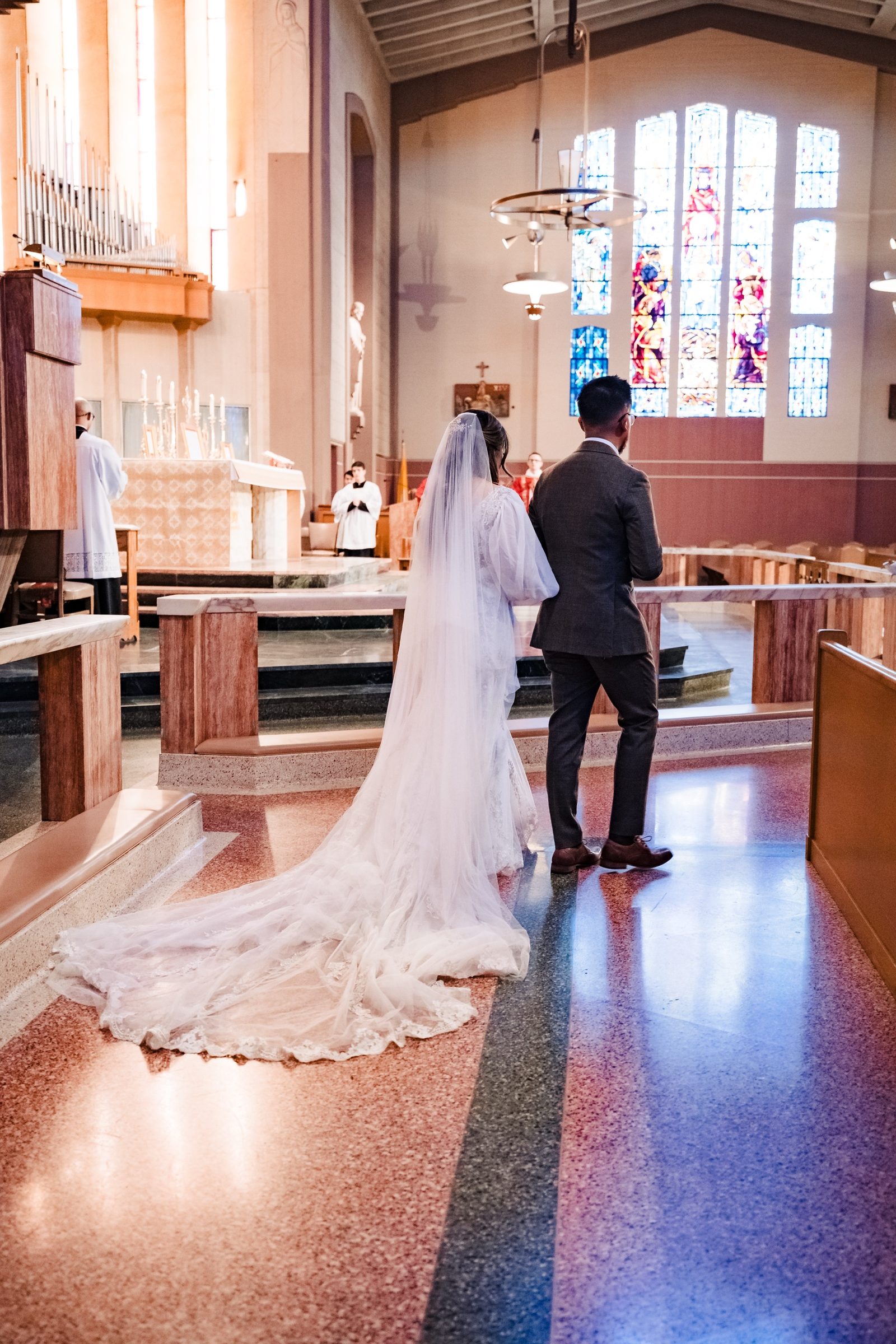 A bride and groom walking toward the sanctuary of St. Therese, Alhambra
