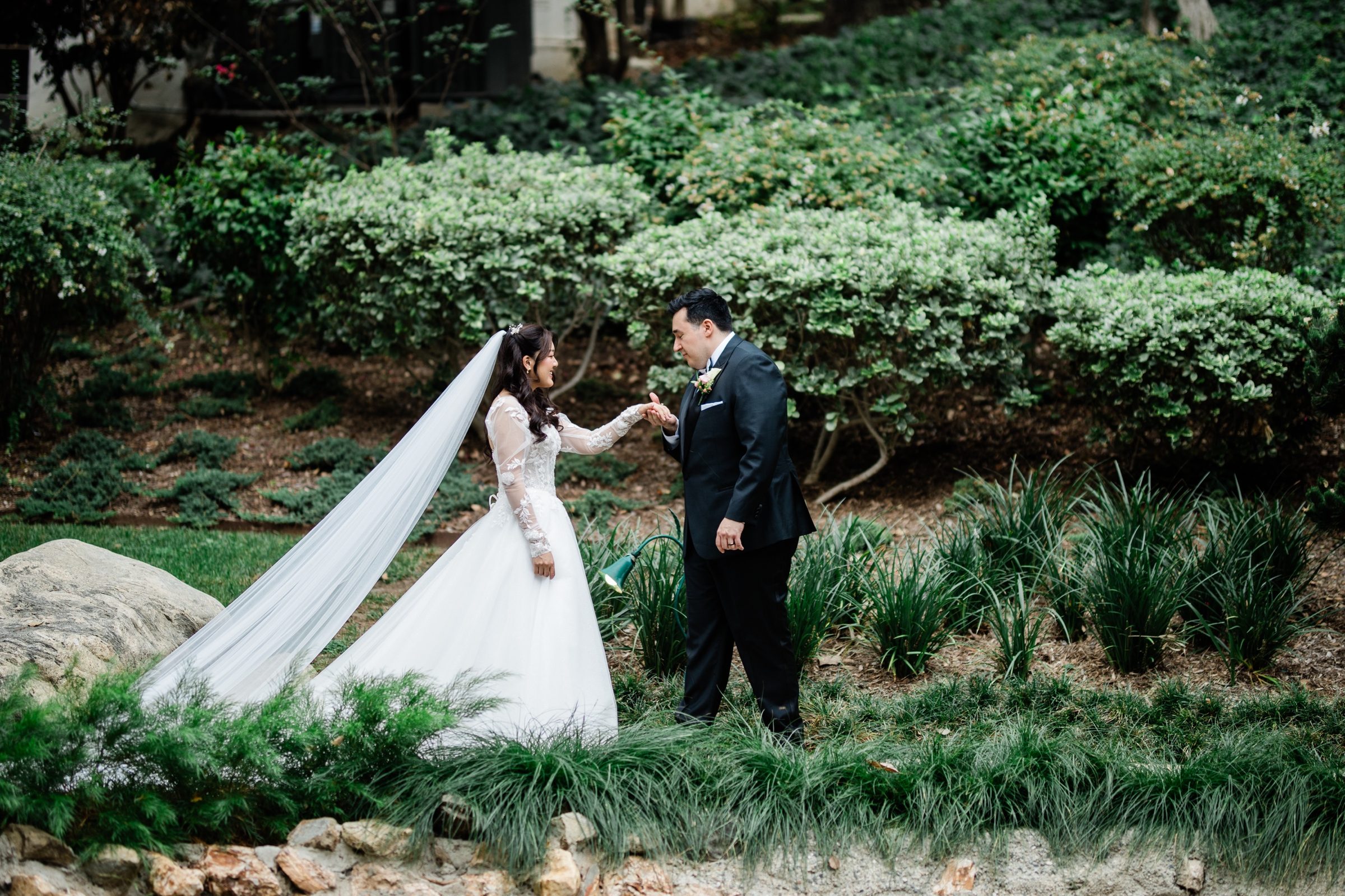 Andrew kissing Candice's hand during portraits in the Langham Japanese garden
