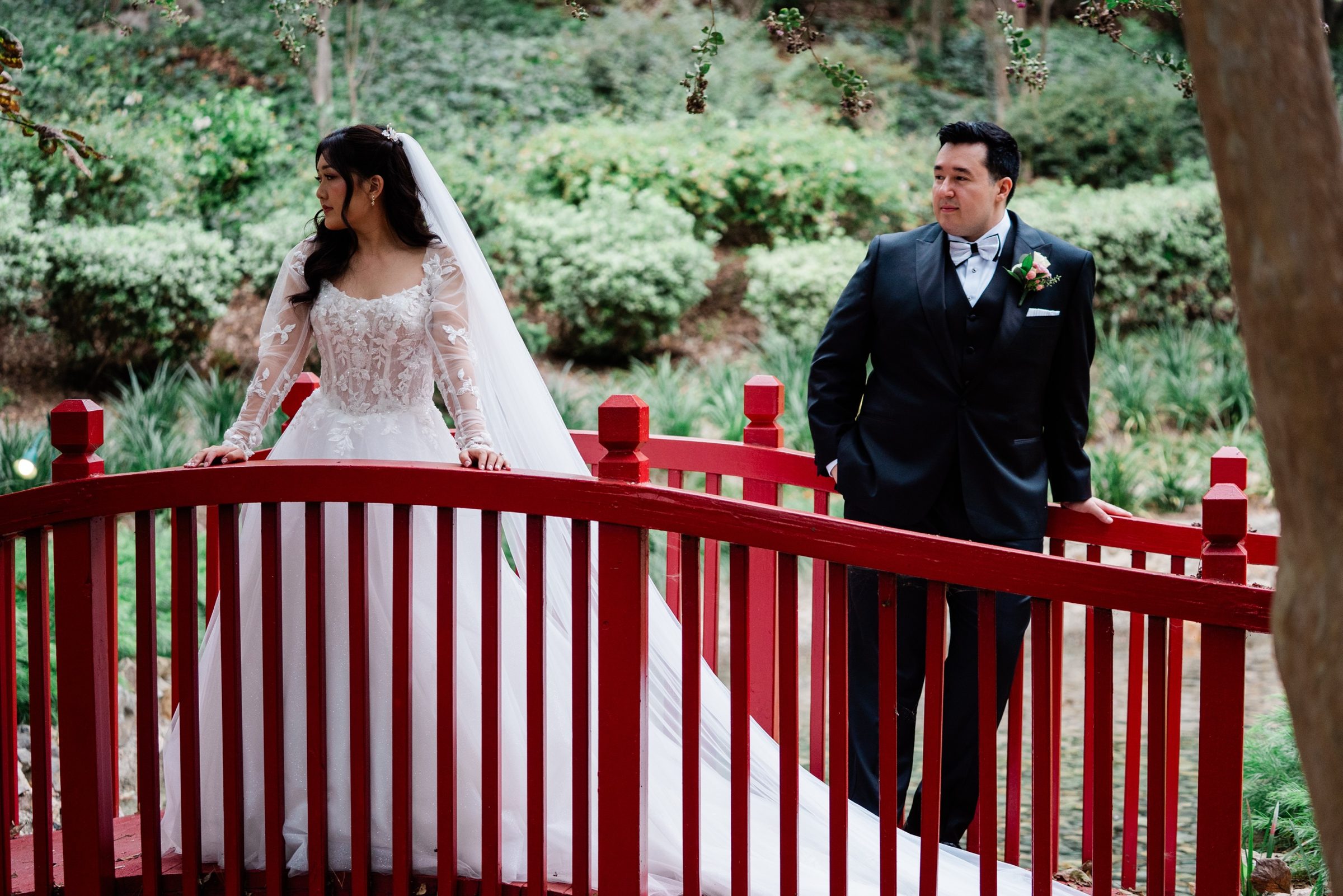 The couple at either end of the red garden bridge