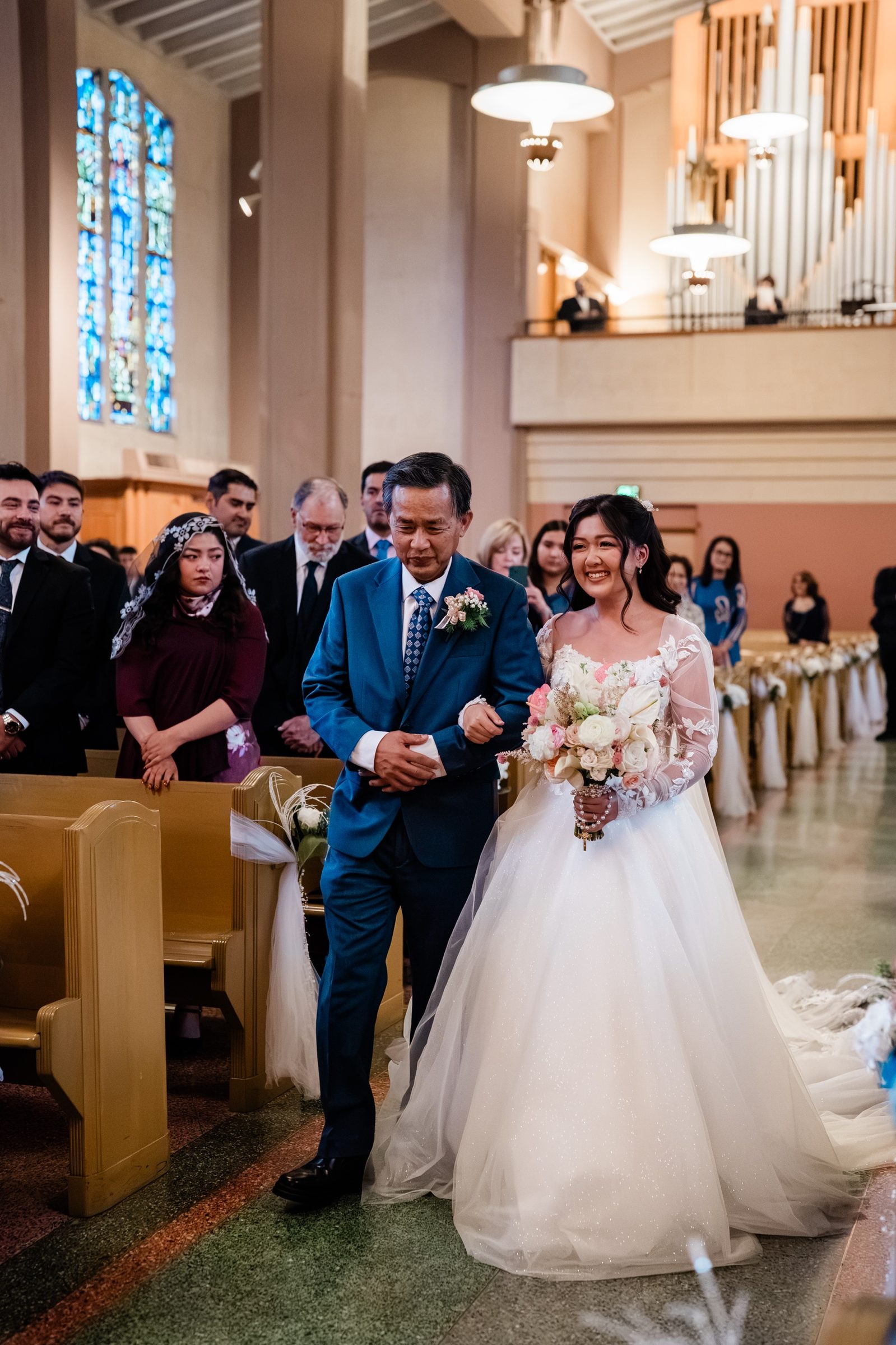 Candice walked down the aisle by her father beneath the organ pipes
