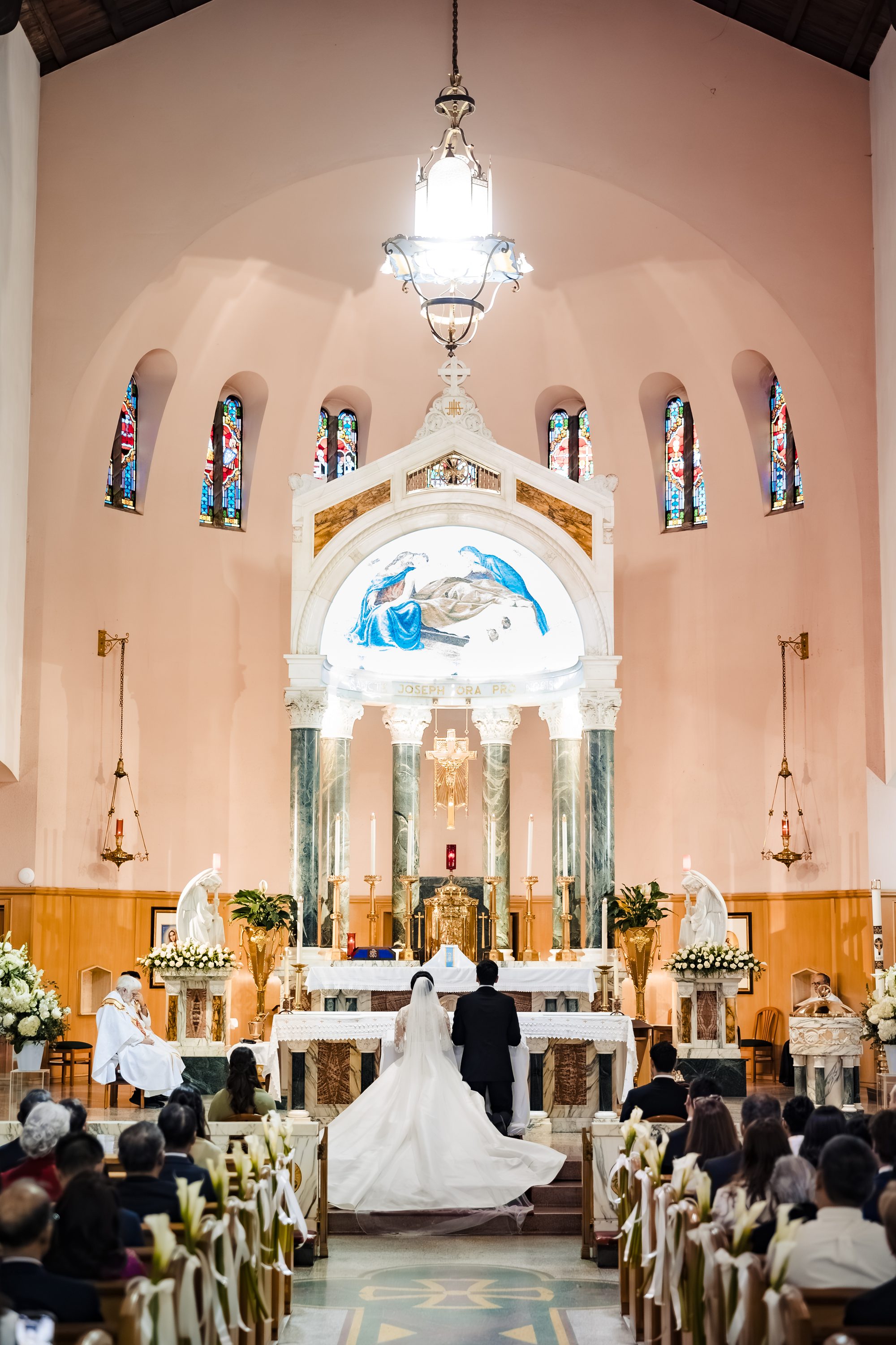 The couple before the Saint Joseph stained glass window at the church