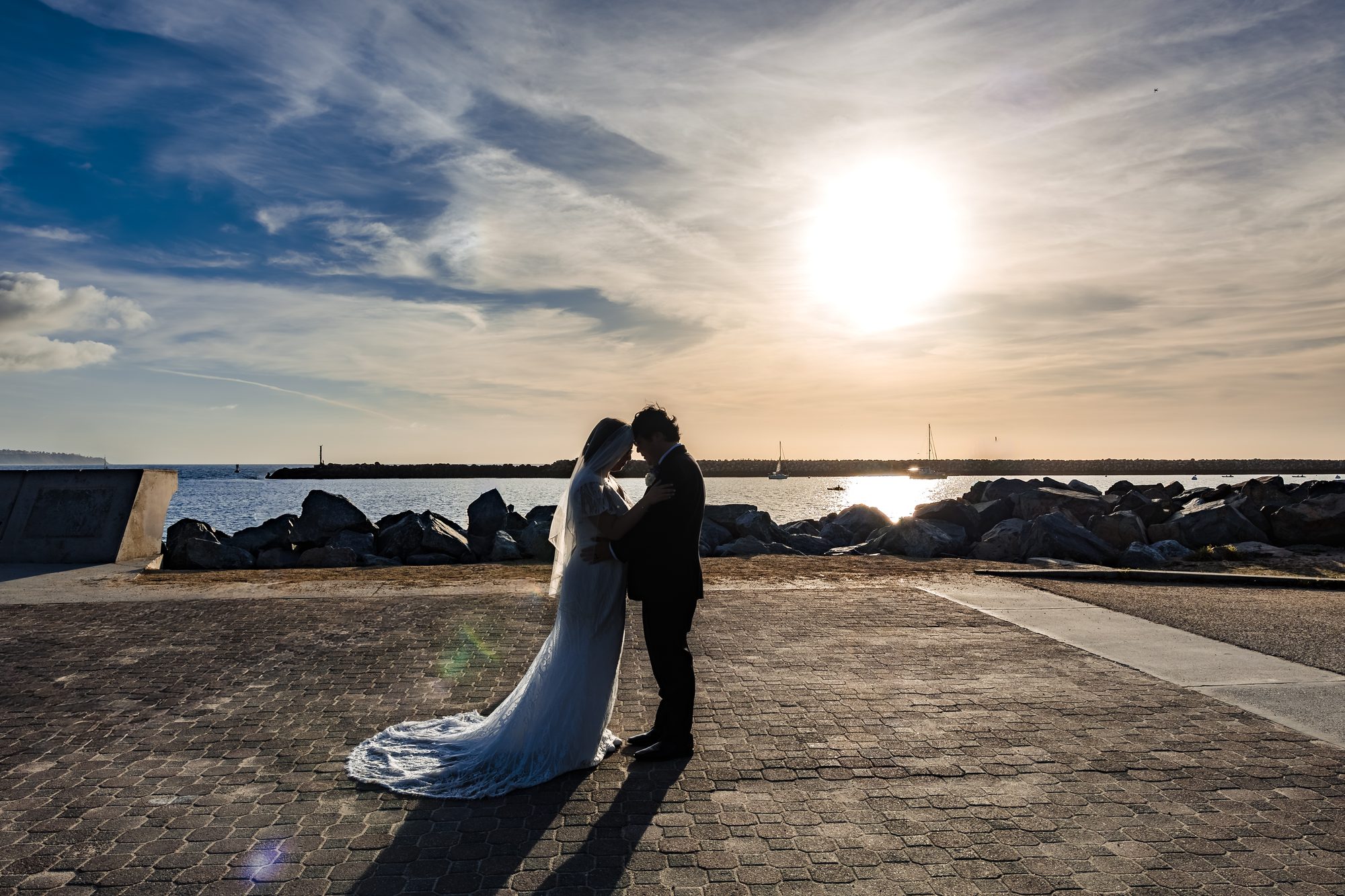 Silhouette of the bride and groom against the setting sun at the Redondo Beach harbor