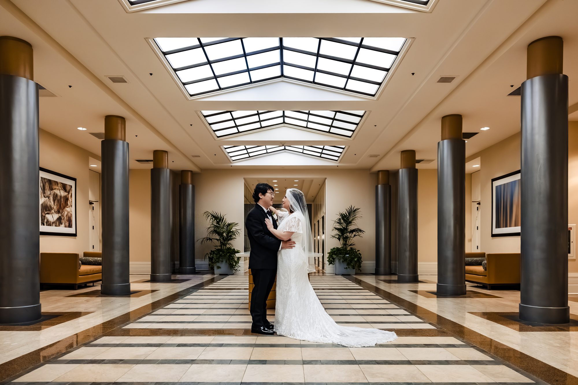 Bride and groom portrait beneath the skylight atrium at the Sonesta in Redondo Beach