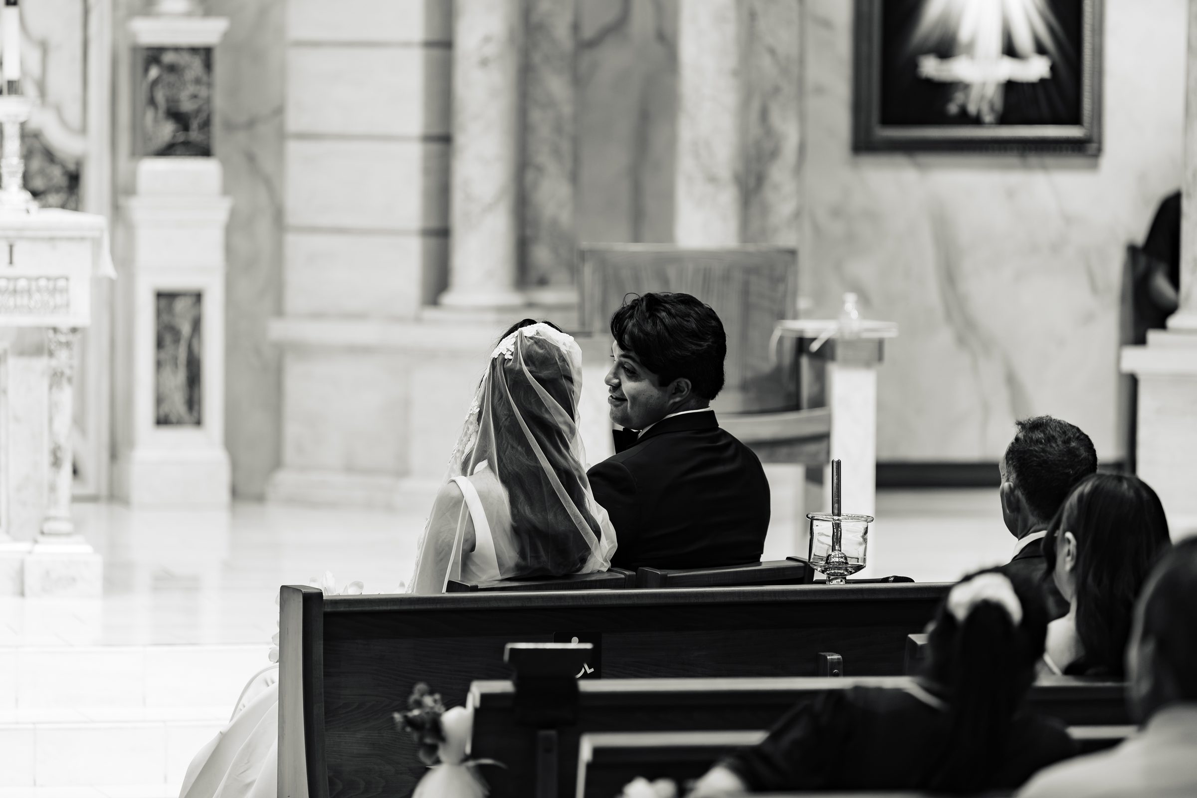 Black and white of the couple listening during the Mass