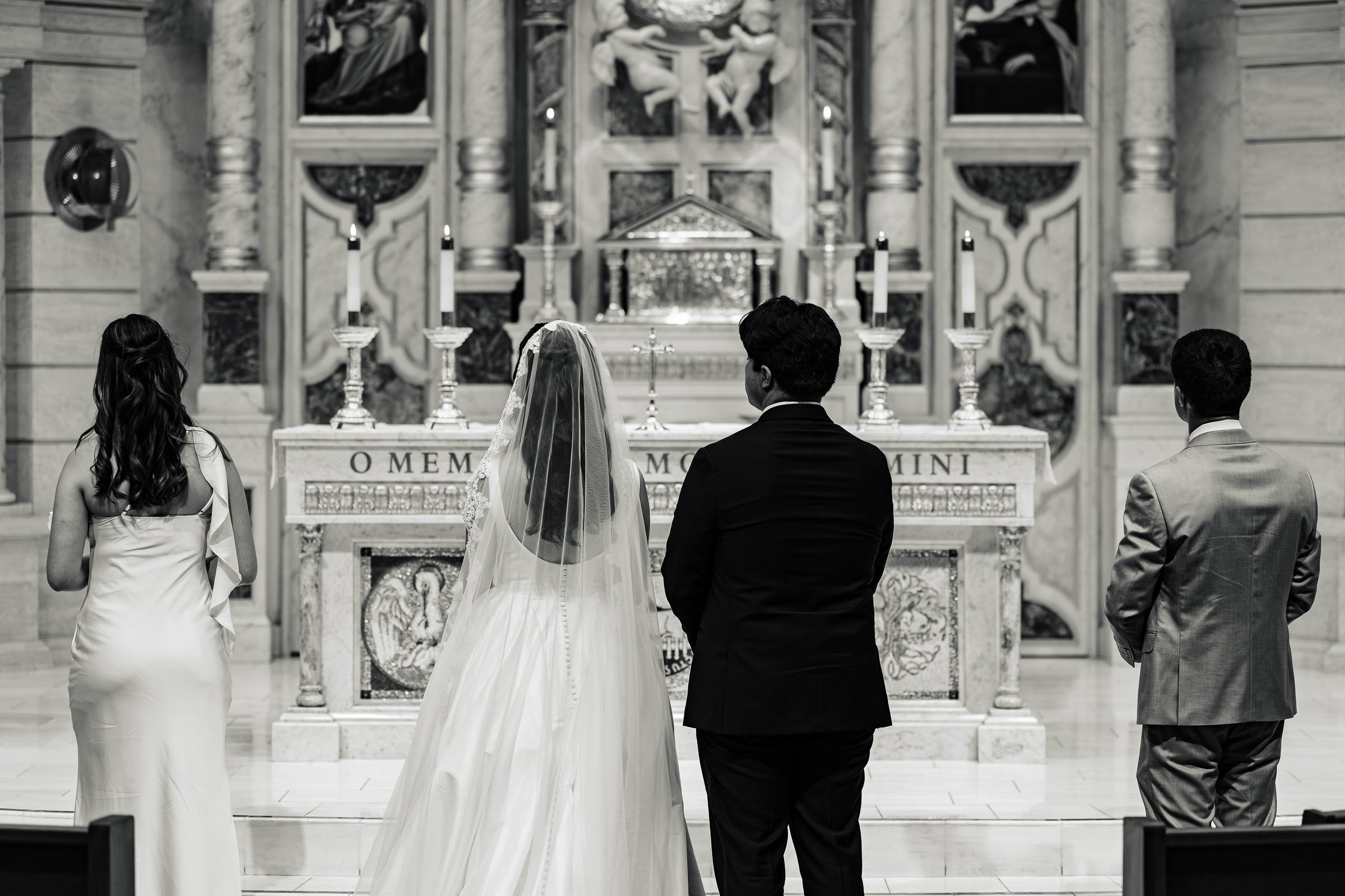 Black and white of the couple and witnesses standing before the altar