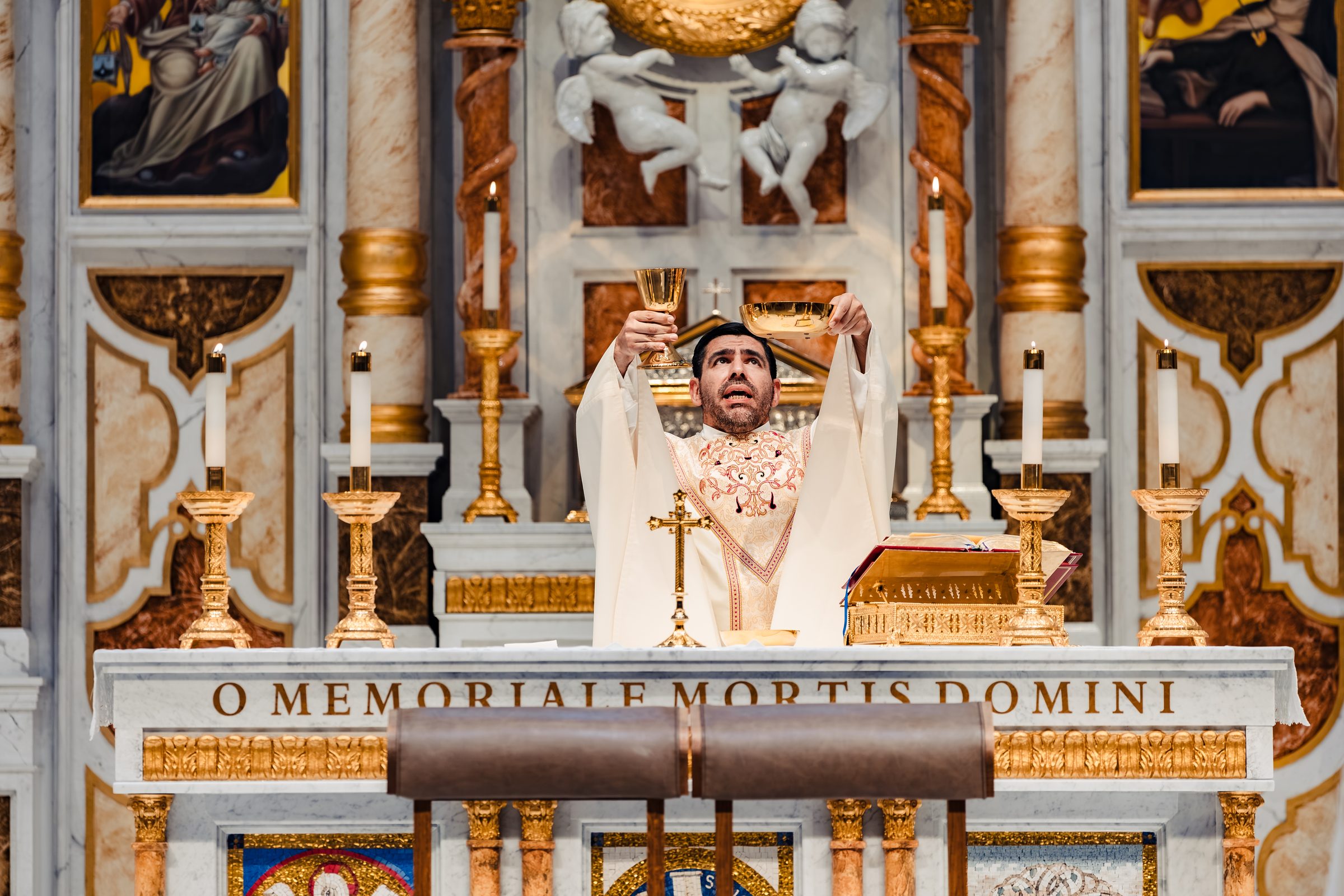 The elevation of the Host above the altar inscribed O Memoriale Mortis Domini