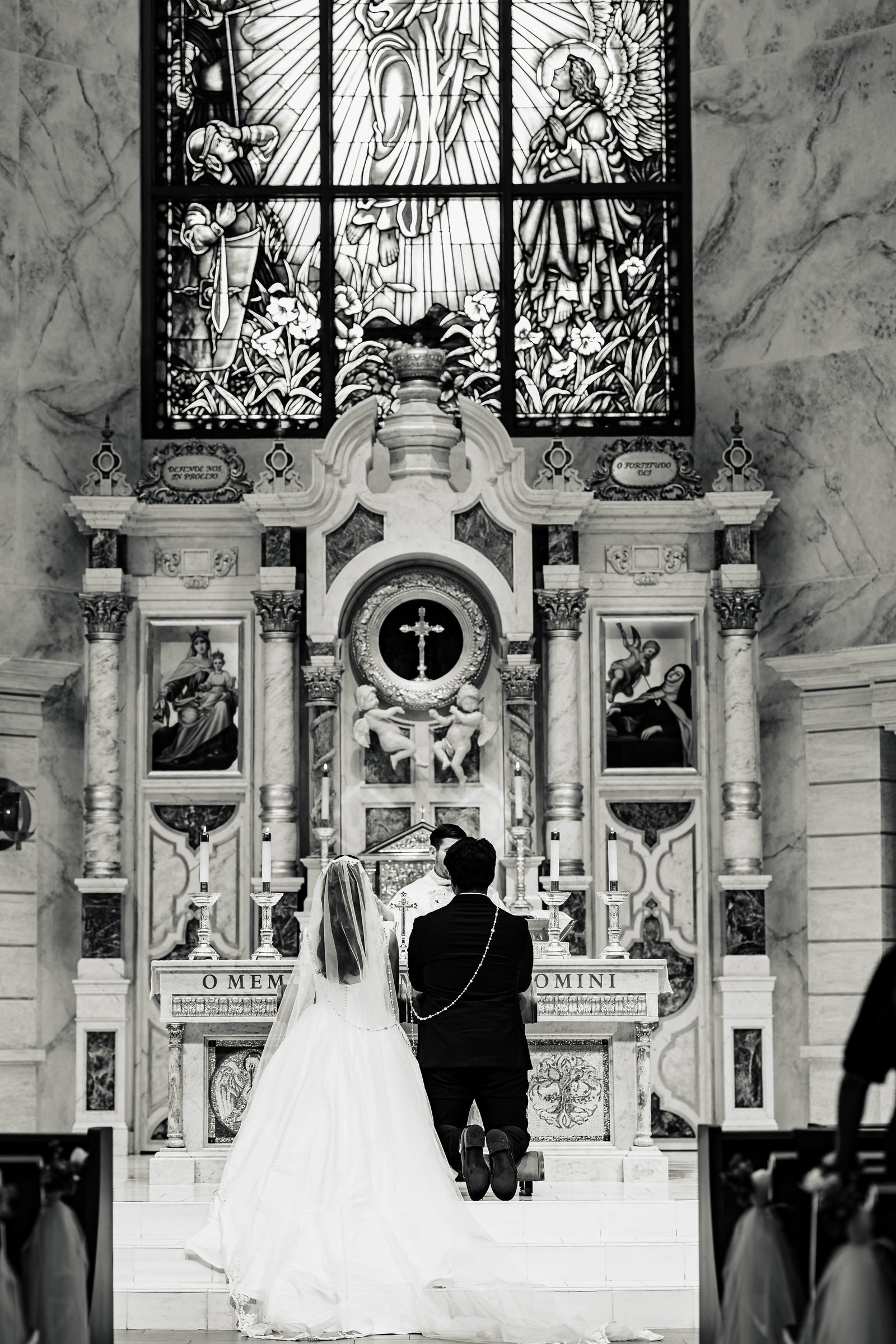 Black and white of the couple kneeling beneath the lazo