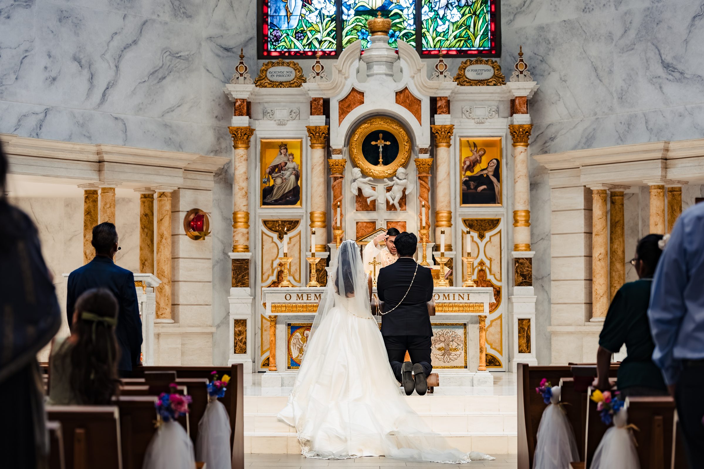 Wide view of the couple kneeling during the Liturgy of the Eucharist
