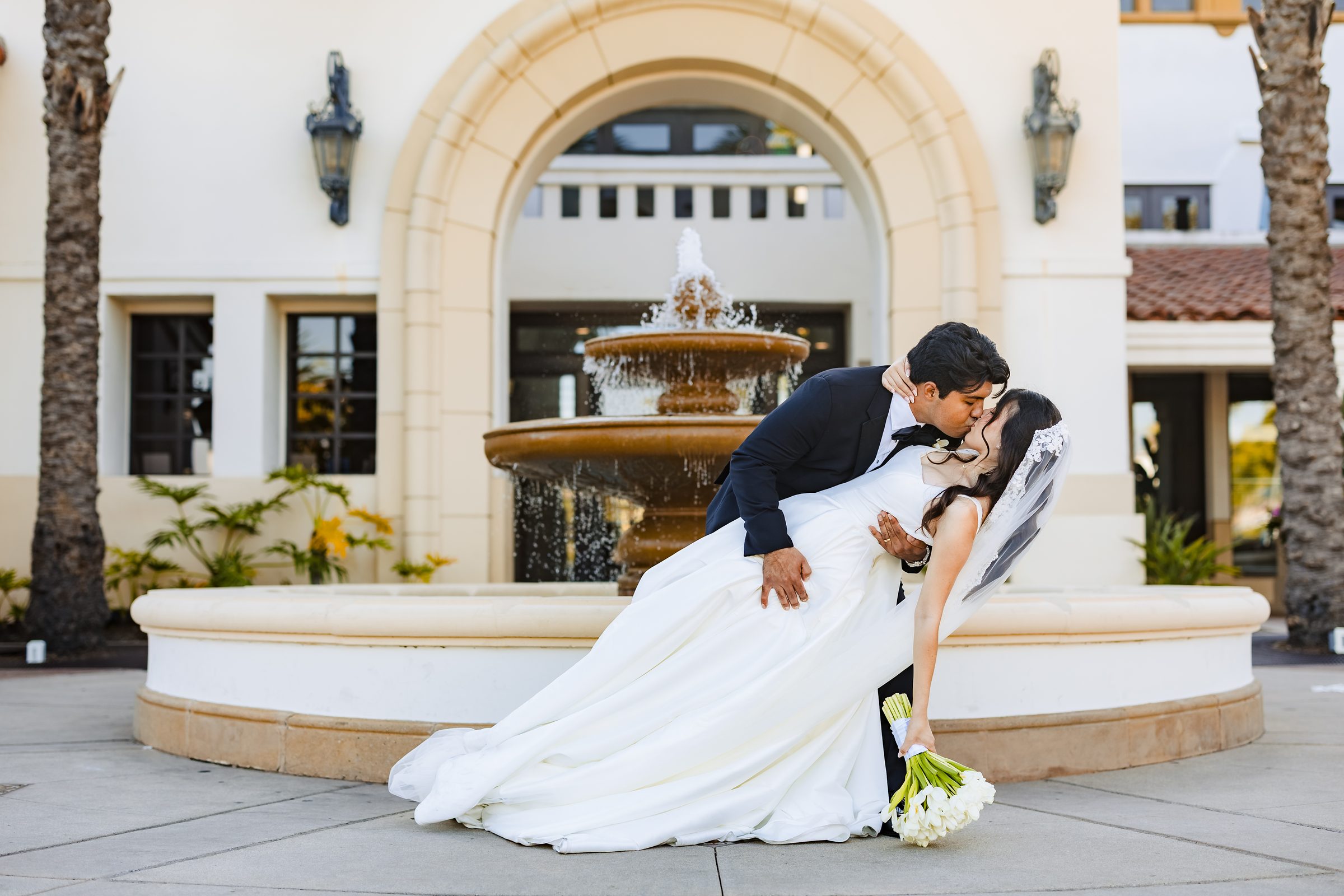 Diego dipping Judith for a kiss in front of the fountain and arch