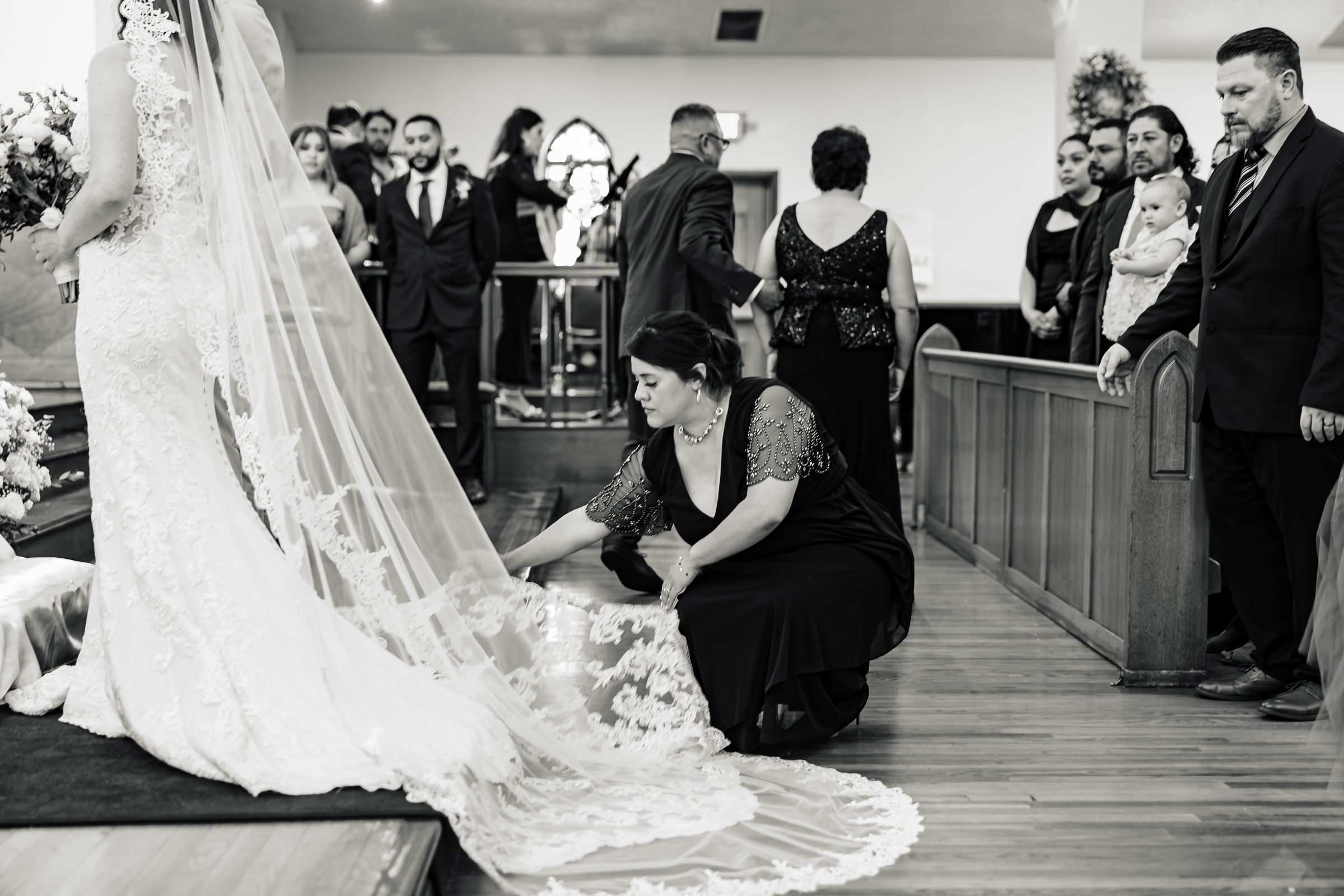 Black and white detail of the cathedral-length veil being arranged