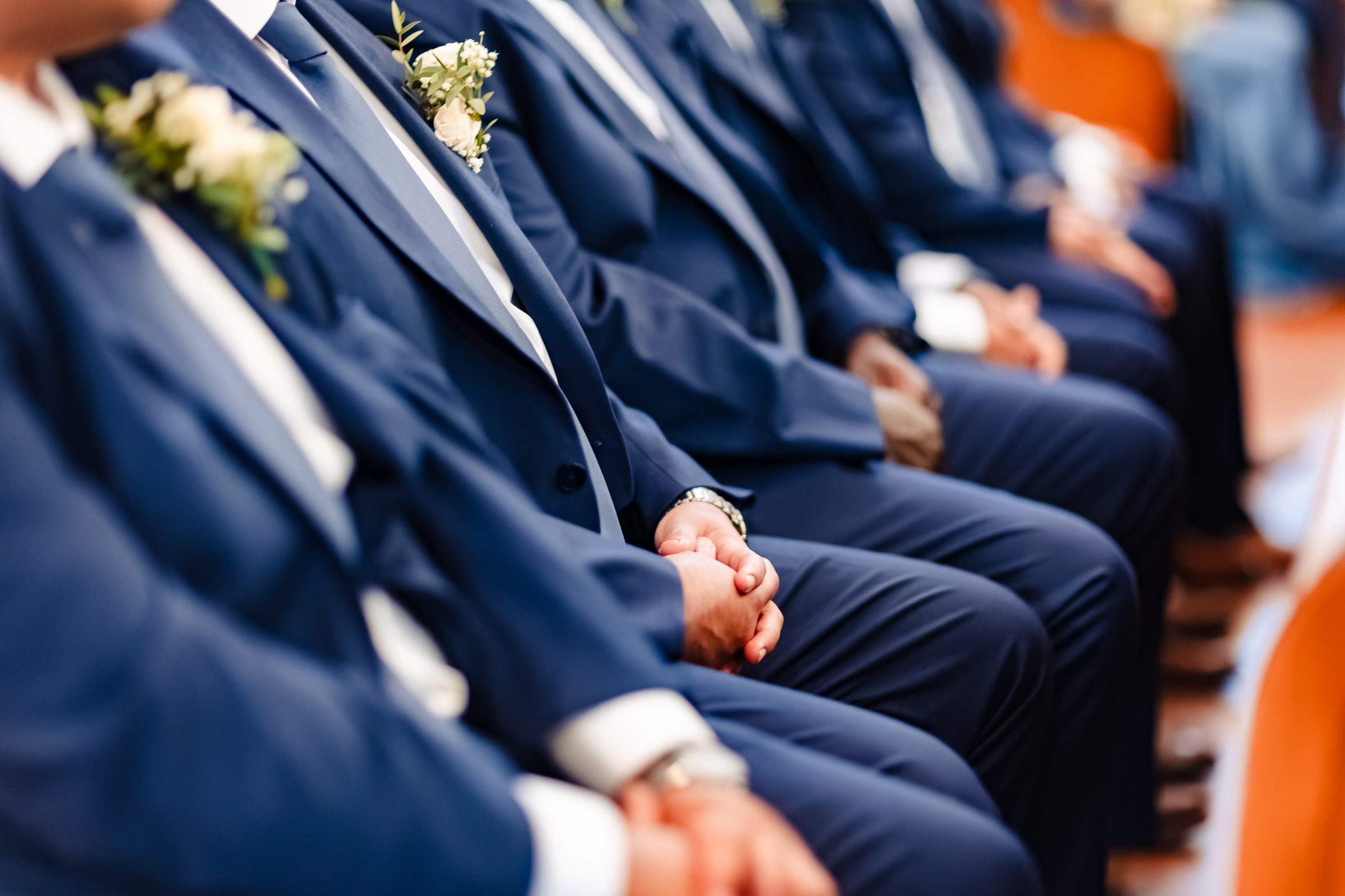 Groomsmen seated in prayer during the Mass